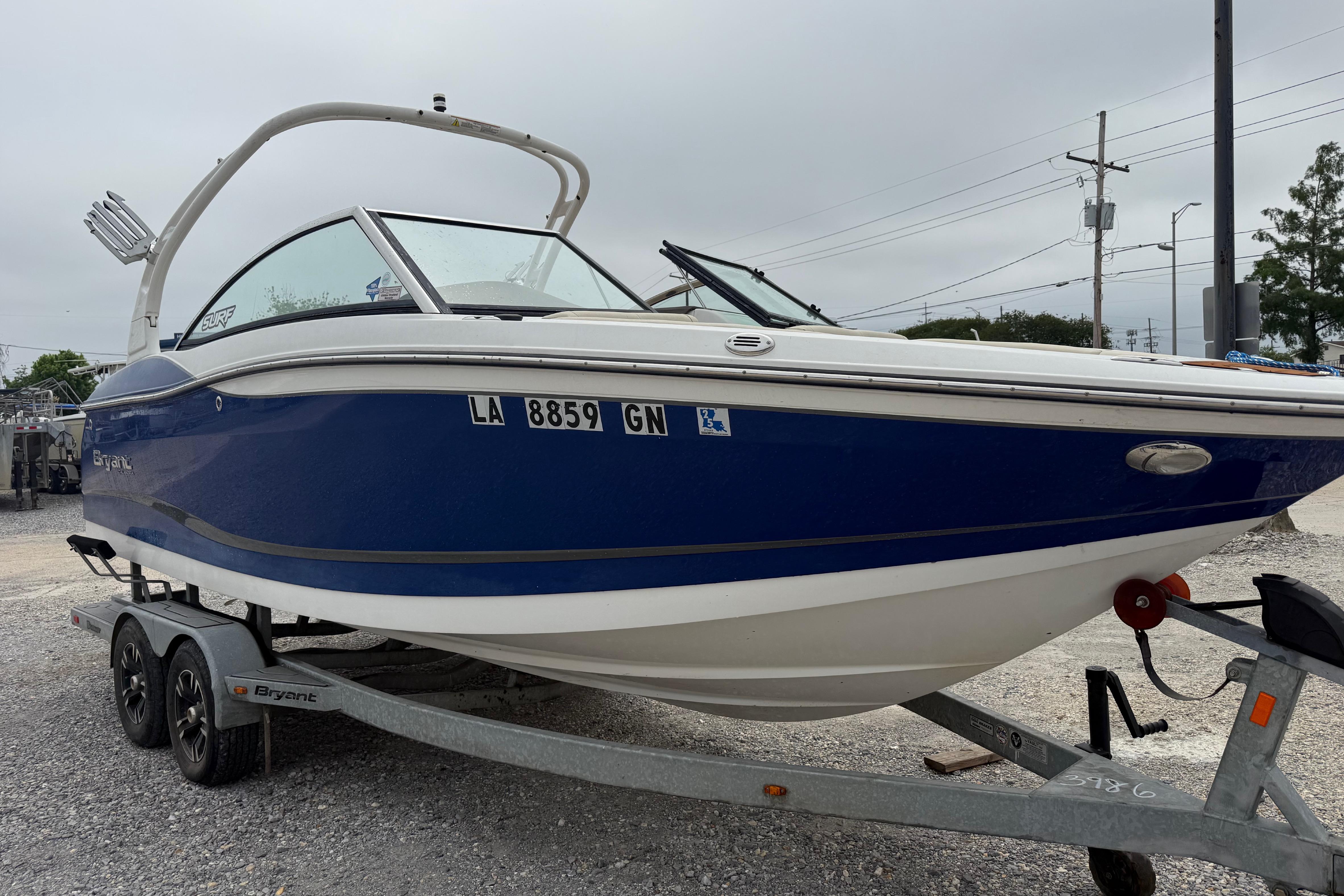 2018 Bryant Calandra boat on trailer, blue and white design, parked outdoors.