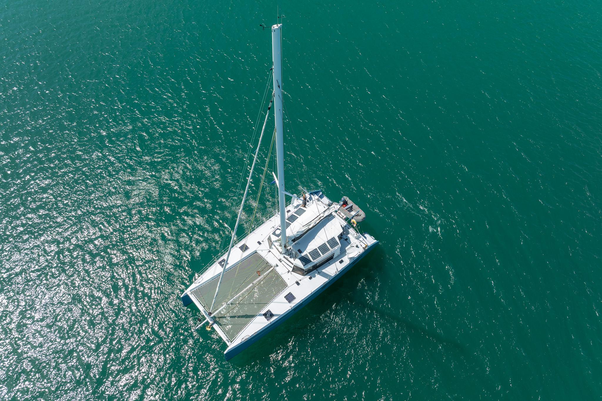 Aerial view of 2015 Custom Mcat 52 catamaran sailing on turquoise water.