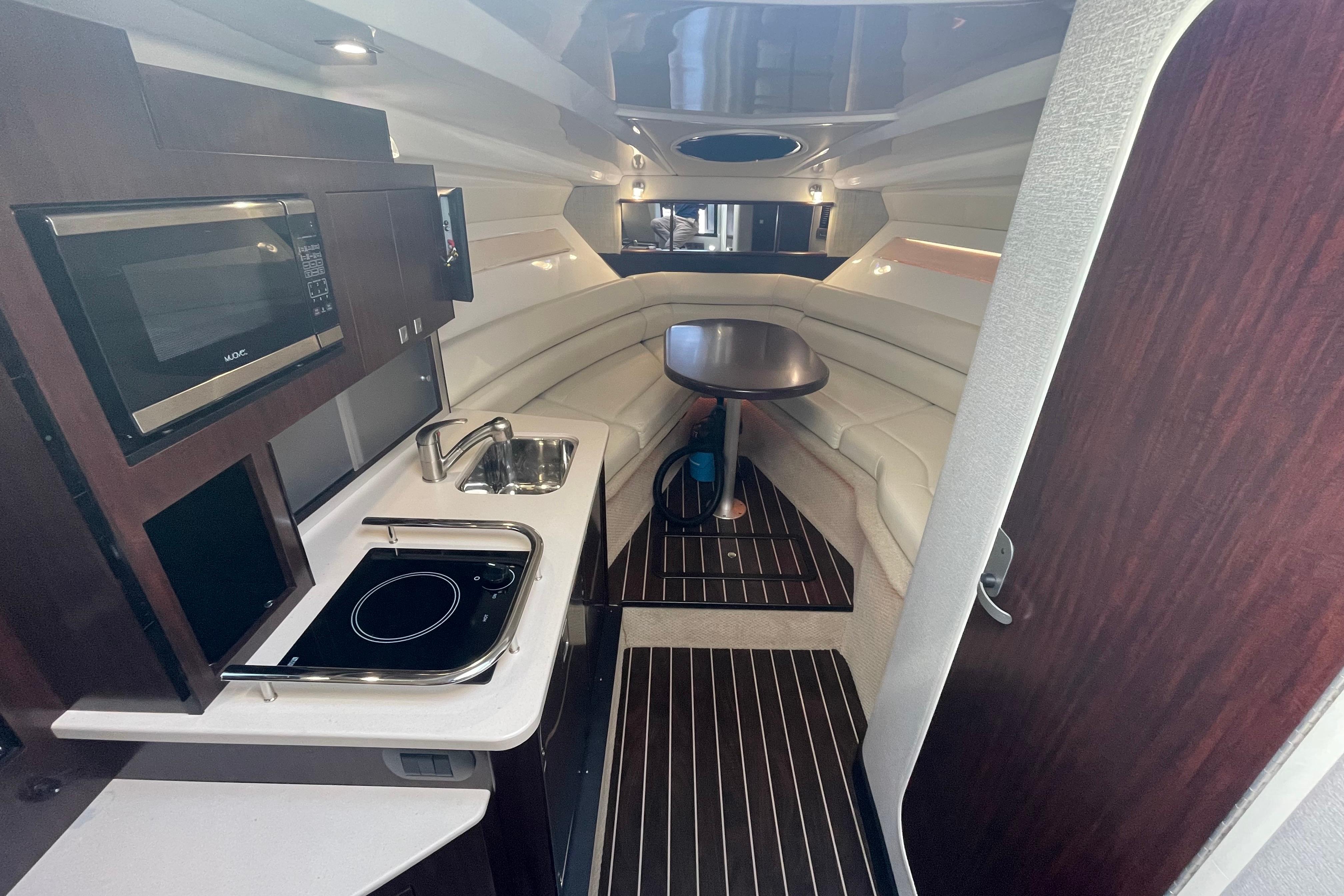2019 Monterey 295 Sport Yacht interior with kitchenette, seating, and dining area.