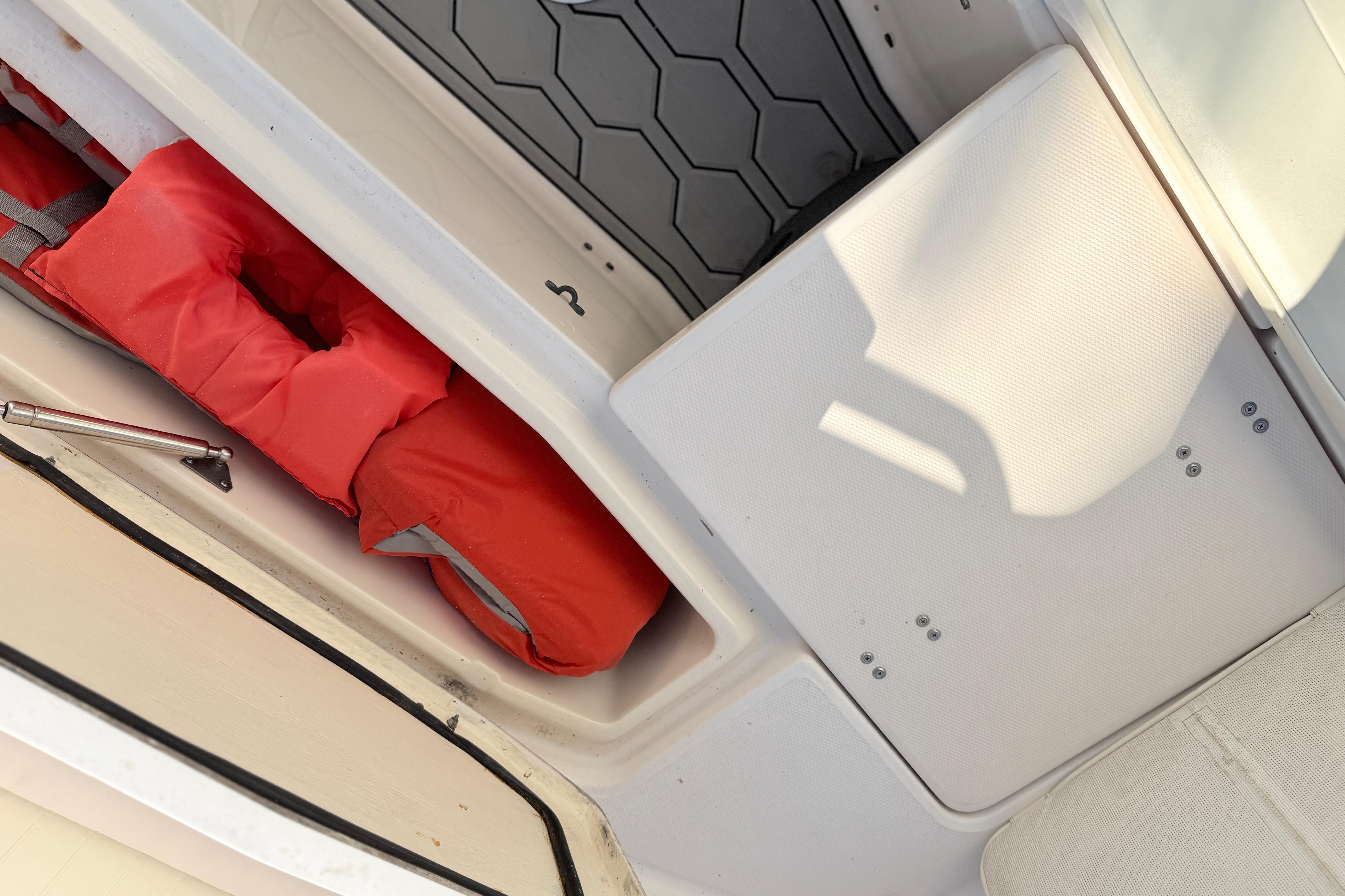 Storage compartment with red life jacket on a 2004 Grady White 273 boat.