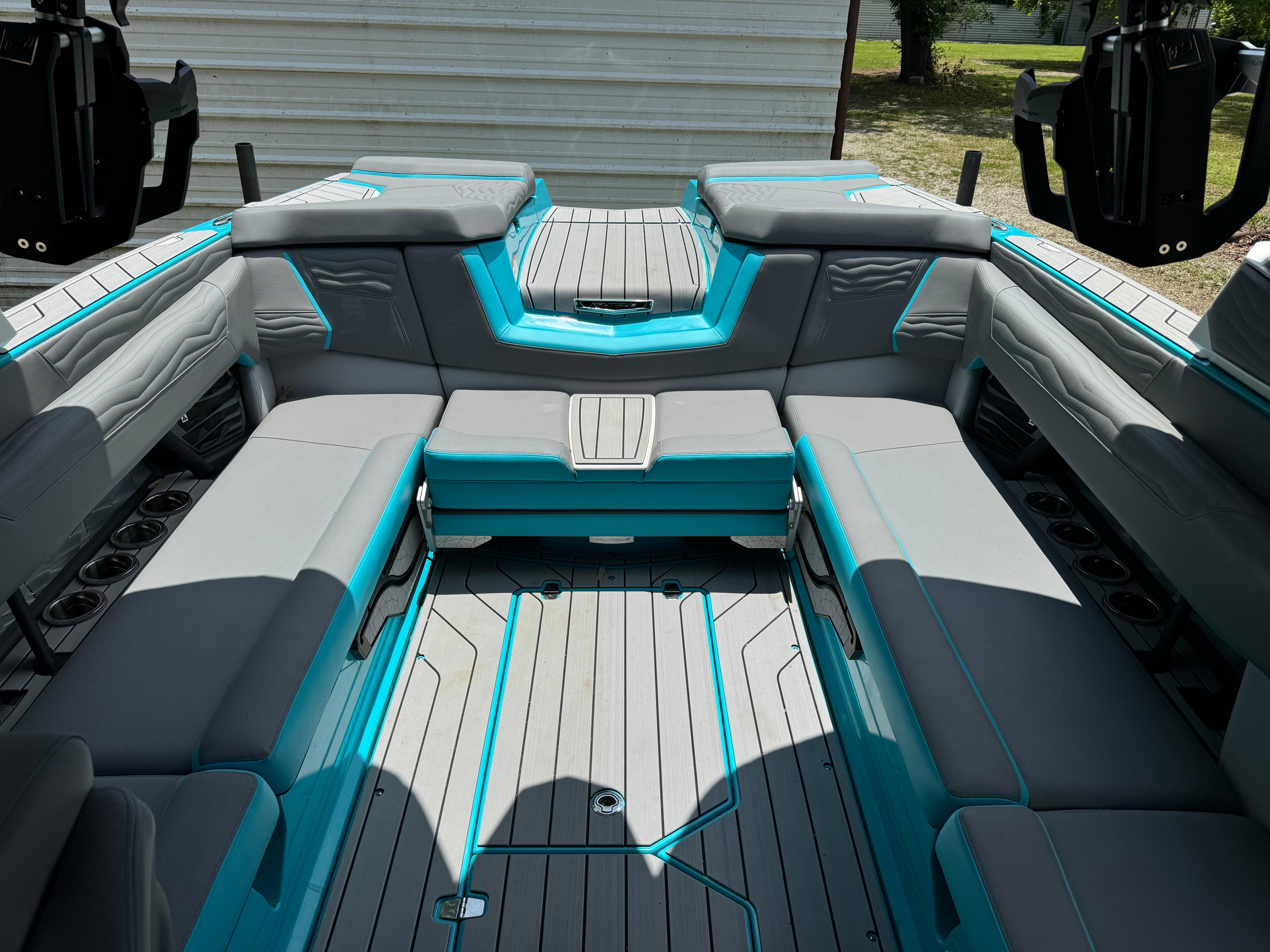 2025 Nautique G25 boat interior with gray and teal seating, spacious layout, and modern design.