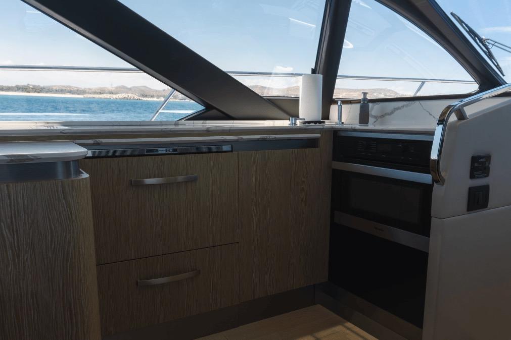 Interior of 2020 Azimut 60 yacht kitchen with modern appliances and ocean view.