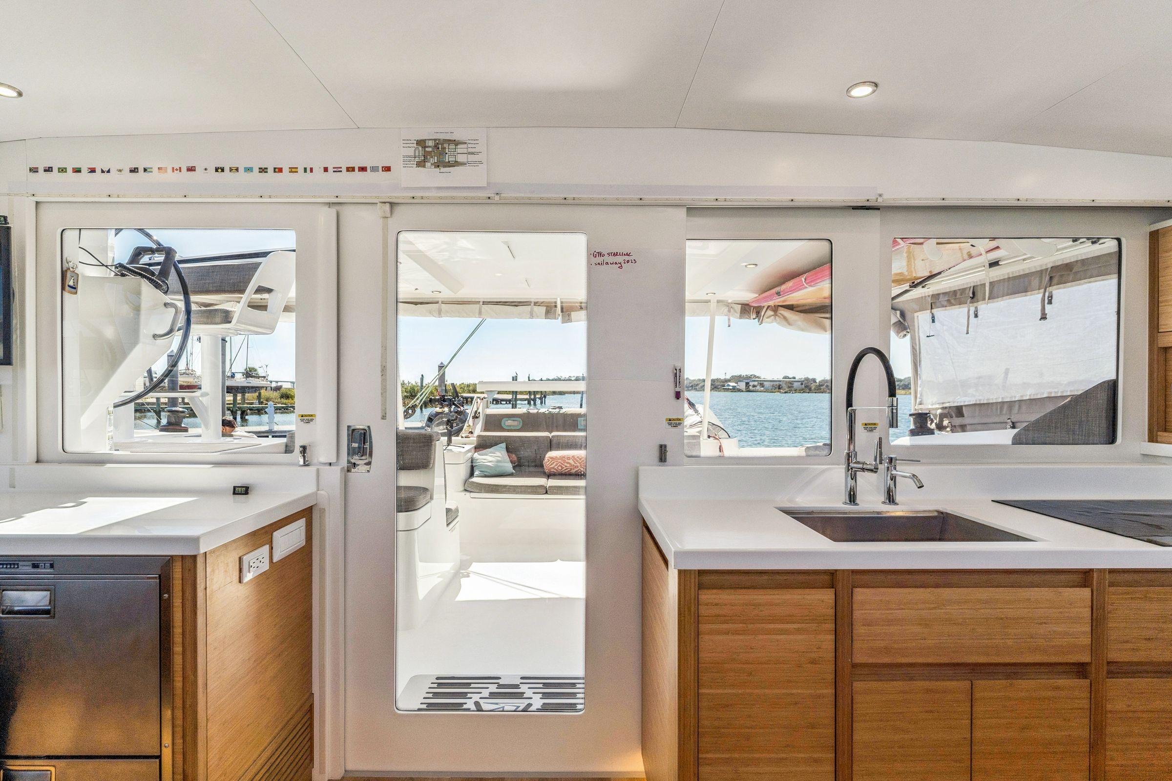 Modern yacht interior with sleek kitchen, large windows, and ocean view; Balance 482, 2024 model.