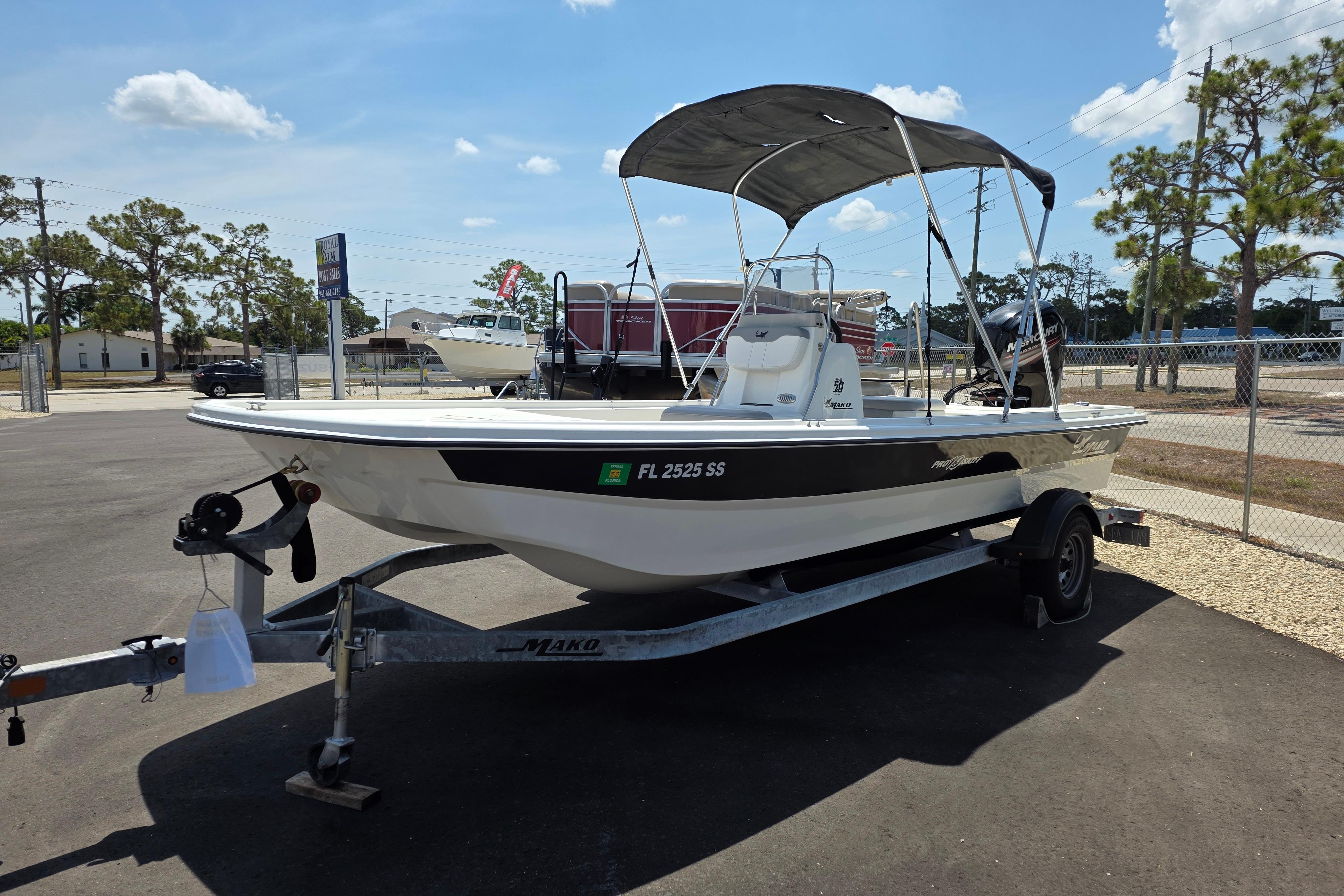 2018 Mako Pro Skiff 19 CC boat on trailer, parked outdoors under clear sky.