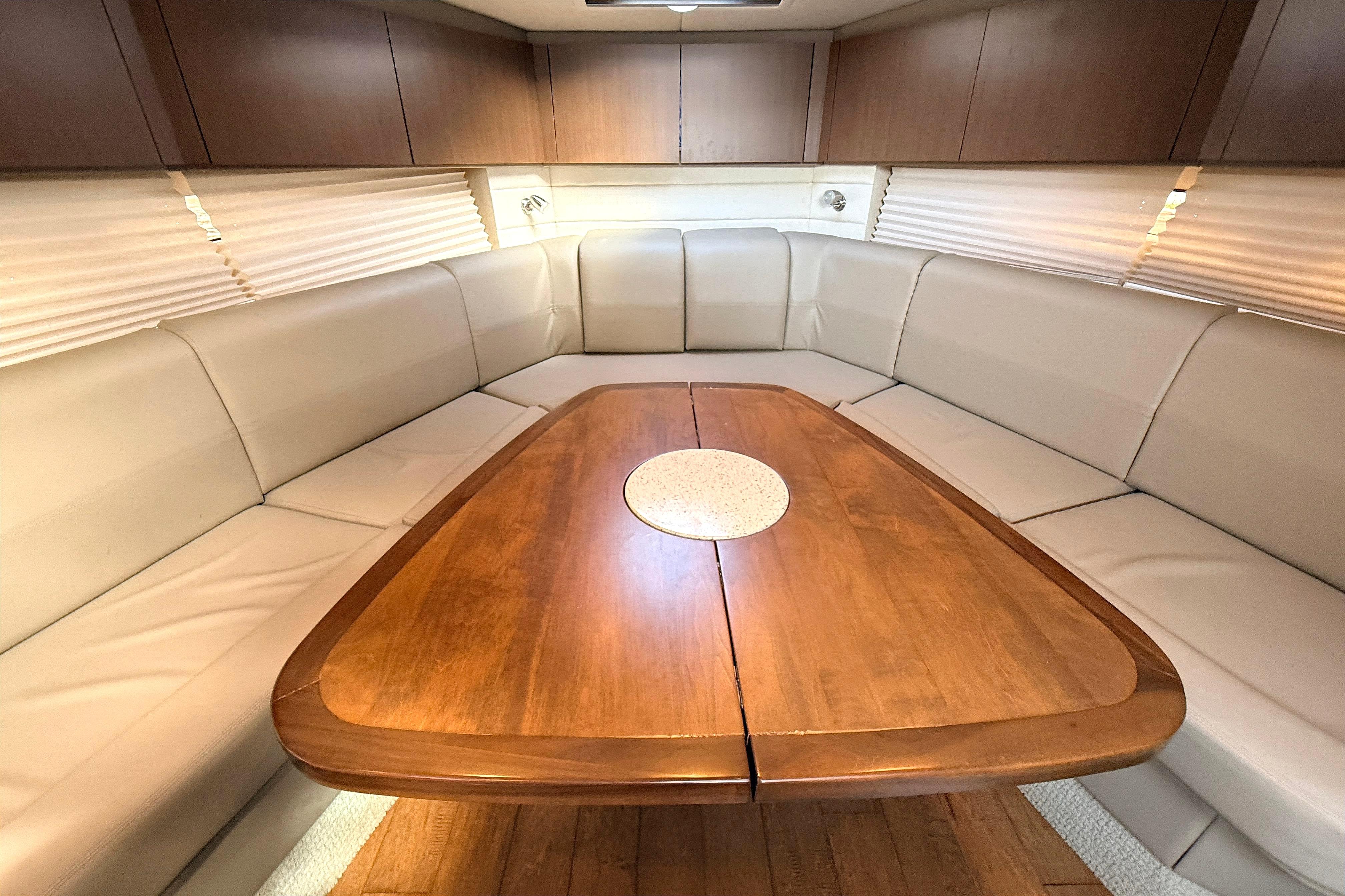 Luxurious interior of 2013 Sea Ray 370 Venture yacht with elegant wood table and plush seating.