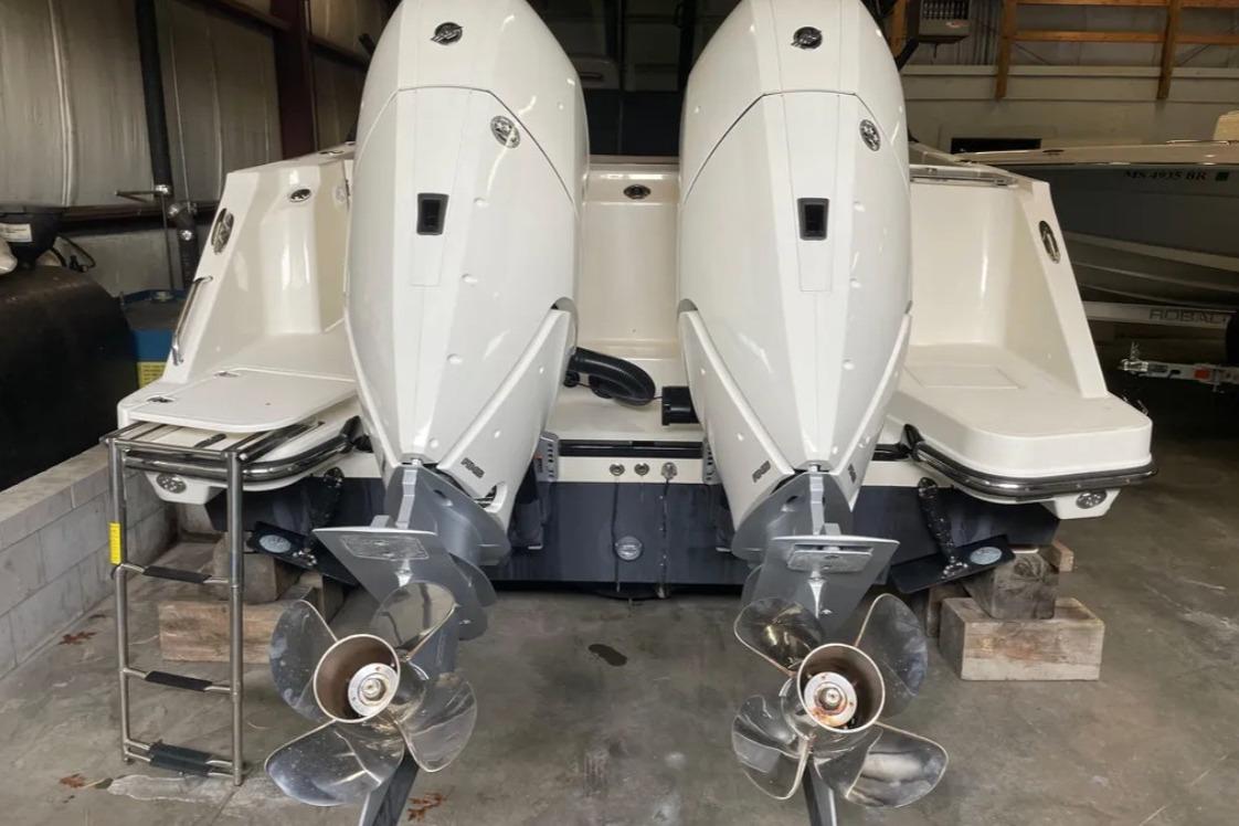 2025 Boston Whaler 330 Vantage with dual outboard engines in a storage facility.