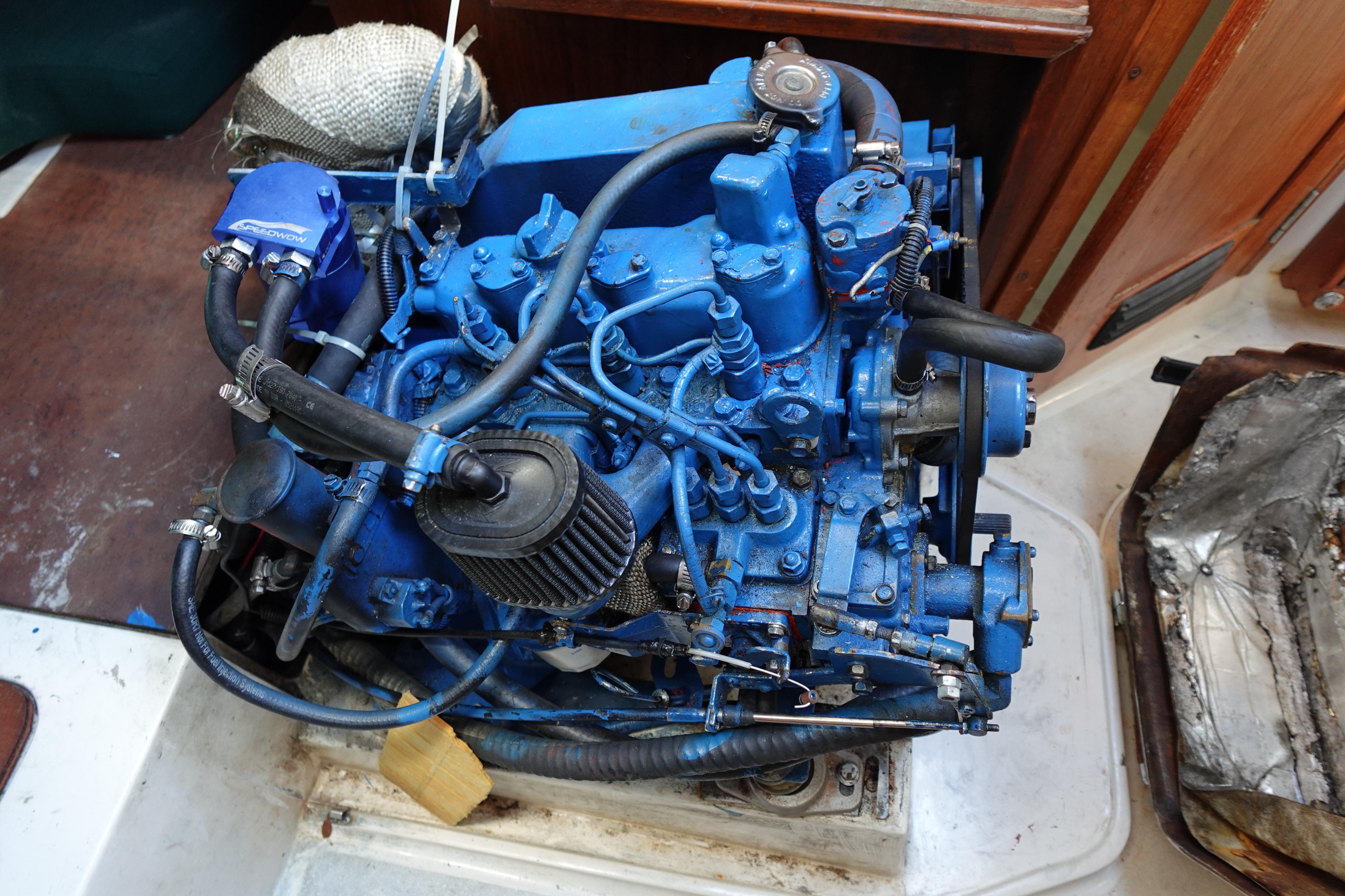 Engine of a 1997 Catalina 28 sailboat, painted blue, with visible hoses and components.