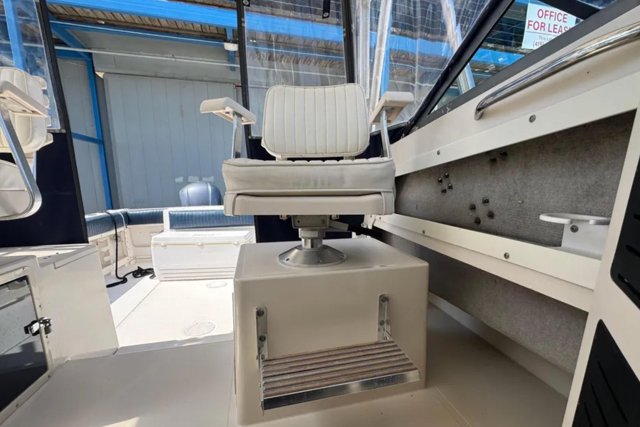 Captain's chair on 1990 Grady-White Marlin 280 boat, featuring a sturdy pedestal base.