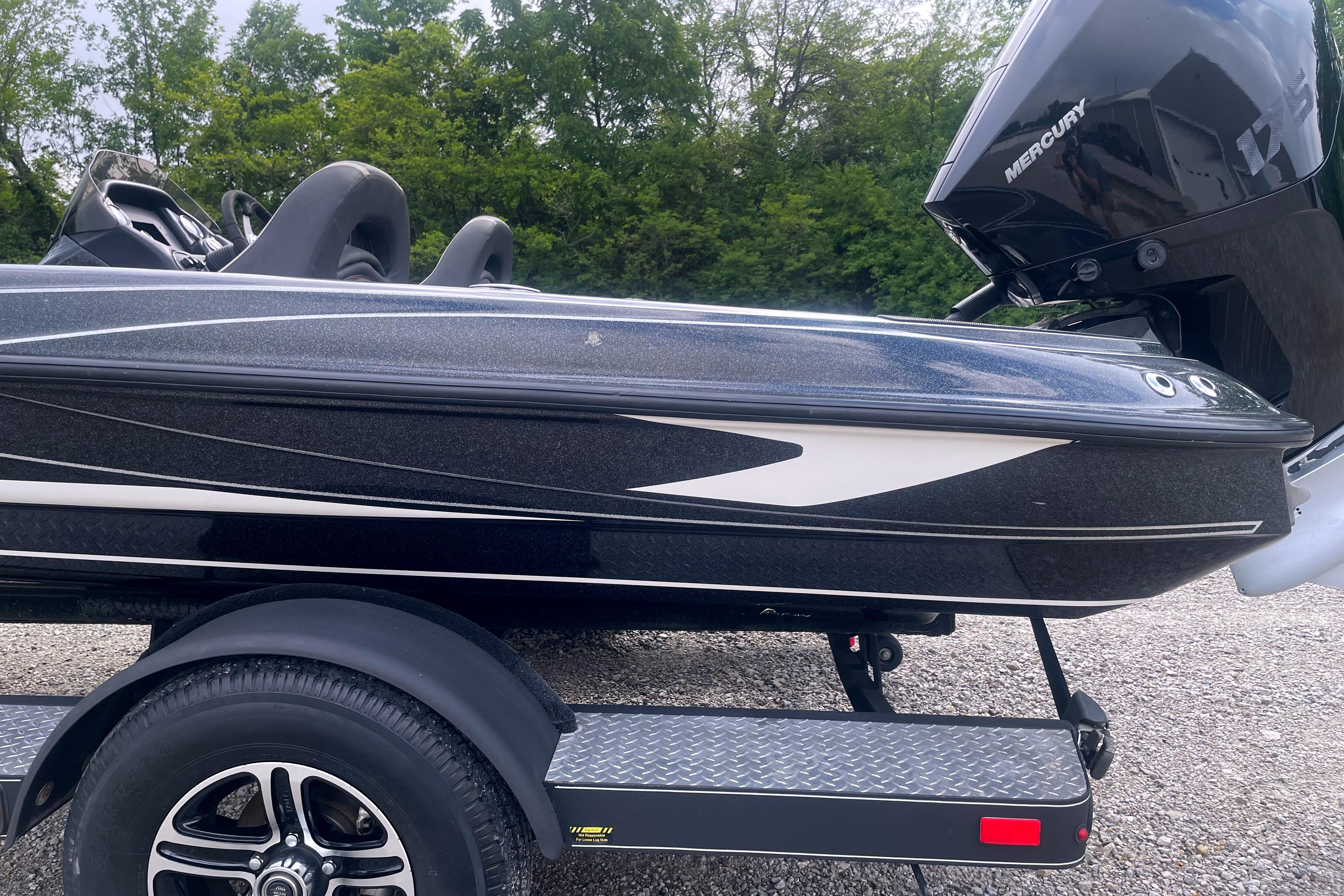 2022 Triton 18 TrX boat with Mercury engine on a trailer, parked outdoors.