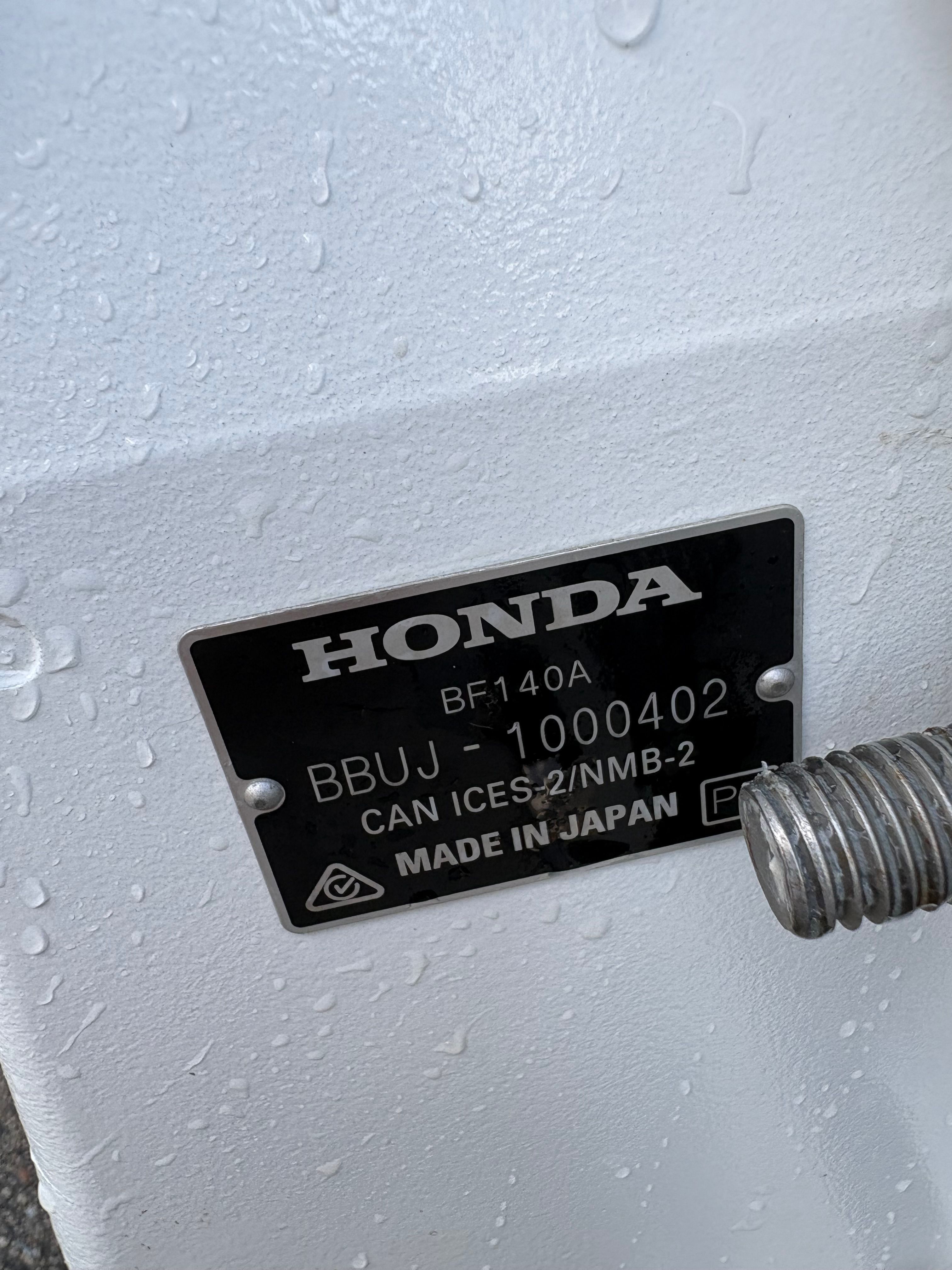 Close-up of a Honda engine plate with serial number and country of origin.