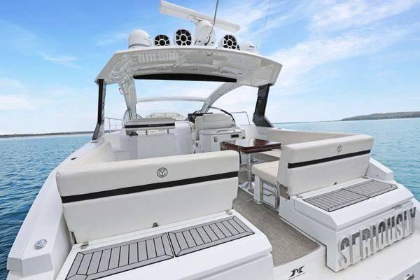 2018 Cruisers Yachts 390 Express Coupe on serene water, showcasing spacious deck and seating.
