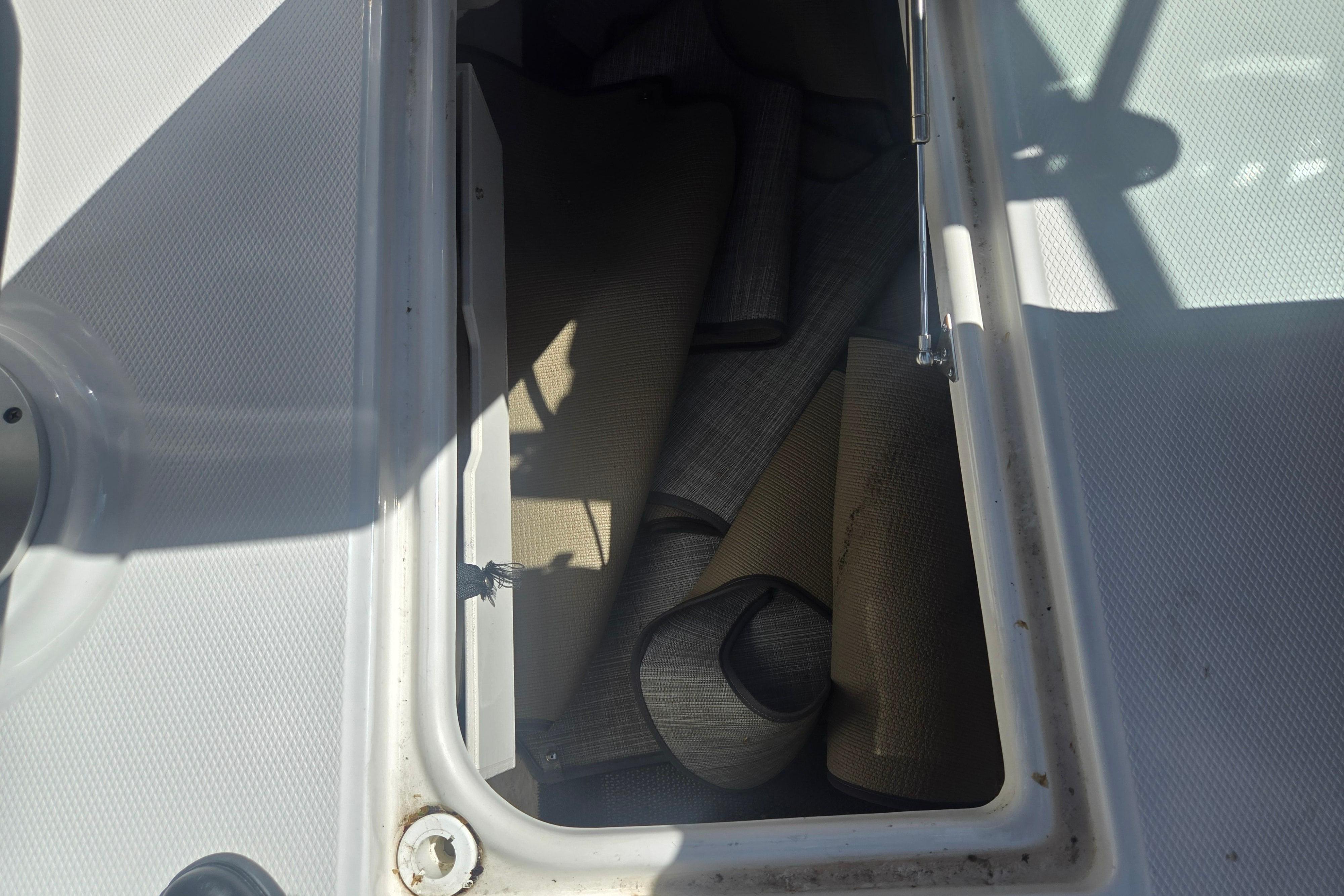 Storage compartment with rolled mats on a 2018 Chaparral 267 SSX boat.