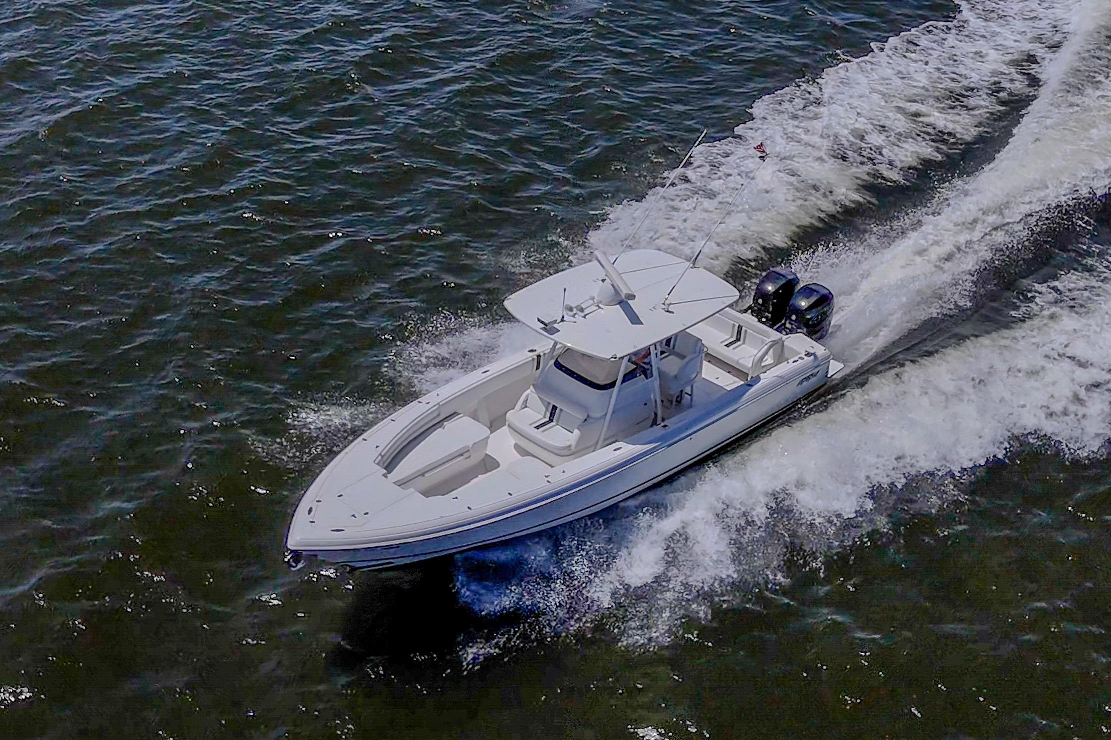 2010 Intrepid 323 OPEN boat cruising on open water, creating a dynamic wake.