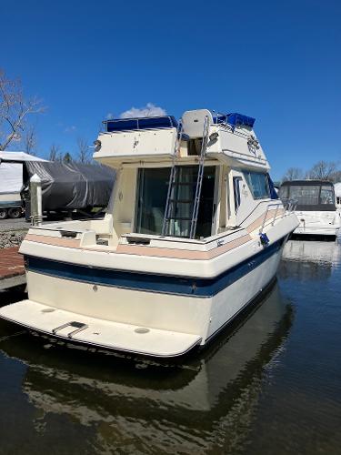 1985 Cruisers Yachts 338 Chateau Vee docked in a marina.