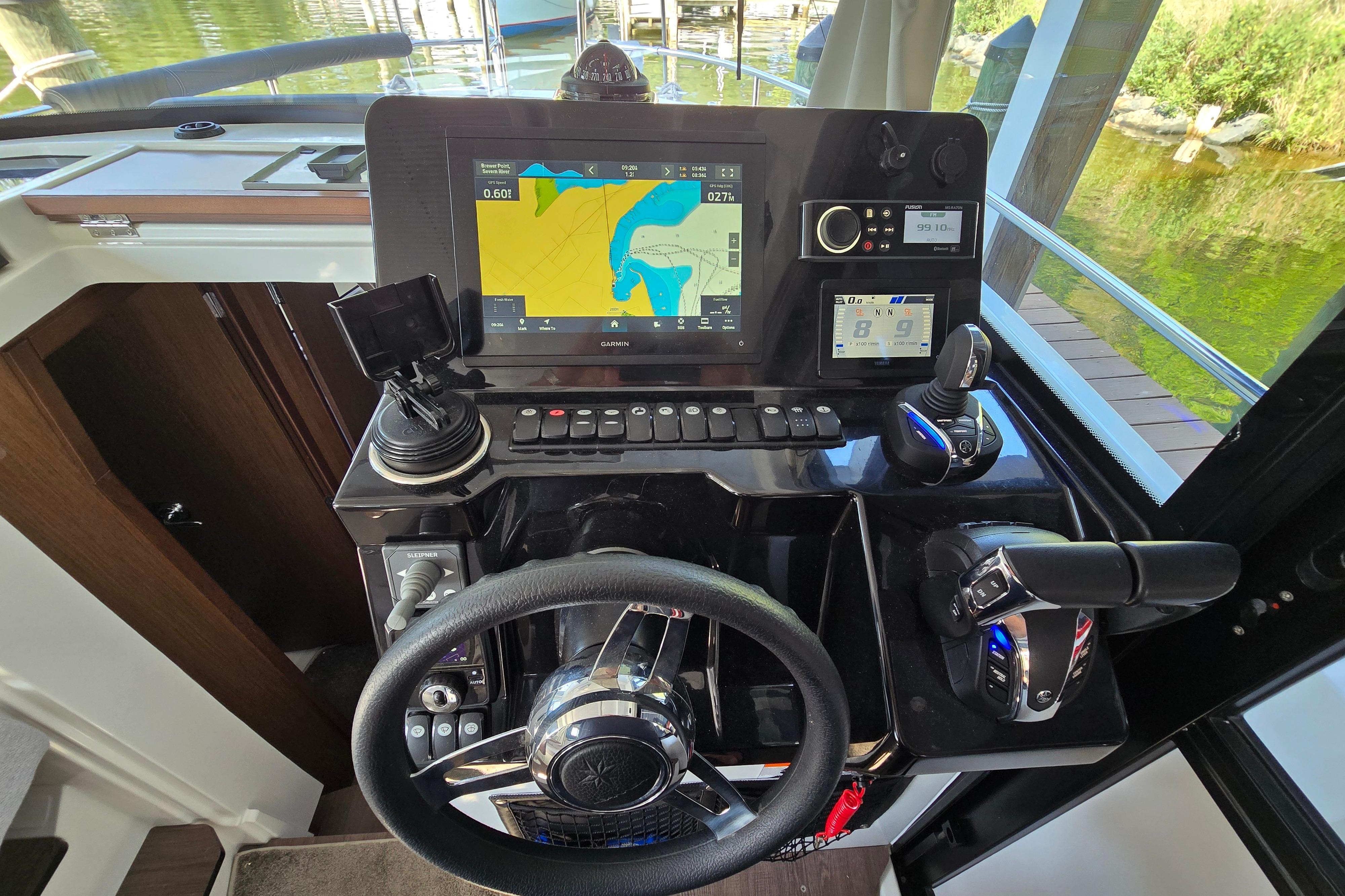 The cockpit of the Jeanneau NC Sport 895 features a modern navigation system and controls.