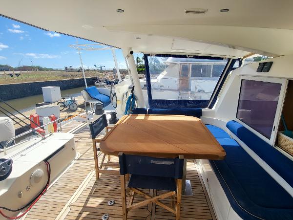 Catana 65 (2009) yacht interior with dining area and outdoor seating.