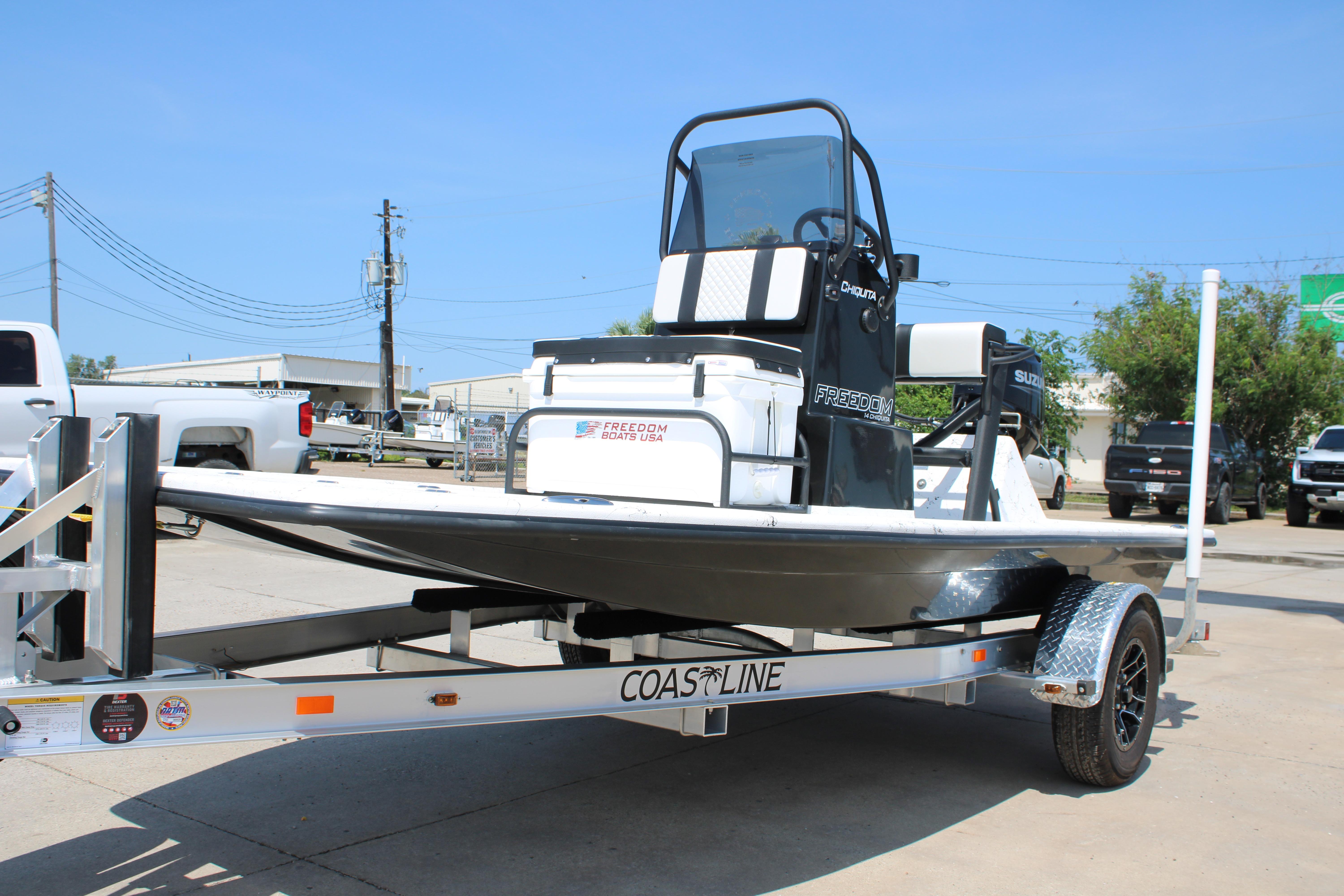 2026 Freedom Boats Chiquita on trailer, parked outdoors under clear blue sky.