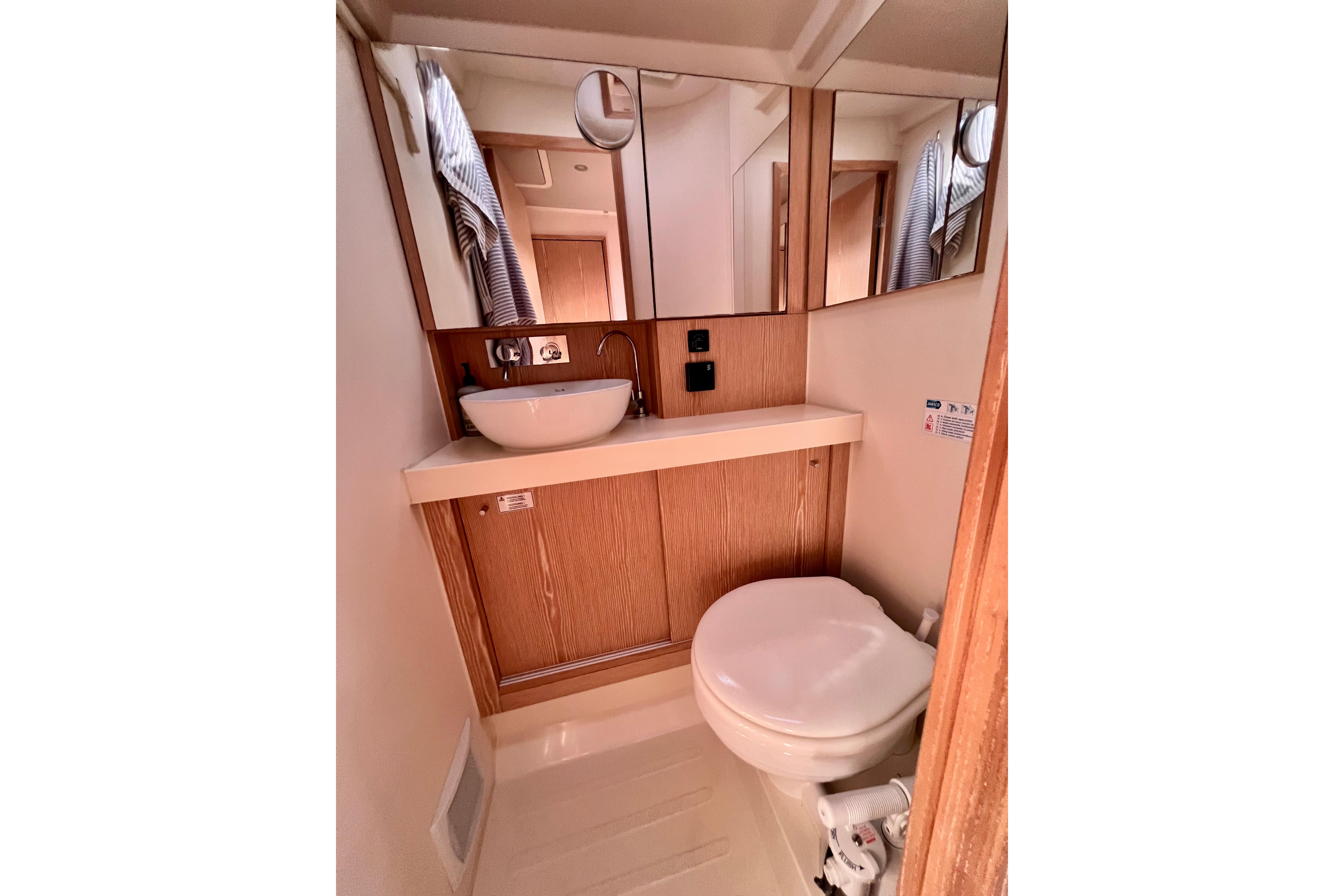 Compact bathroom in 2016 Hanse 455 yacht with sink, mirror, and toilet.
