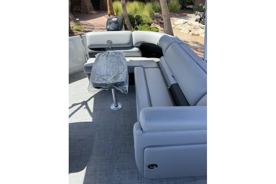 2026 Sun Tracker Party Barge 20 DLX interior with gray seating and table.