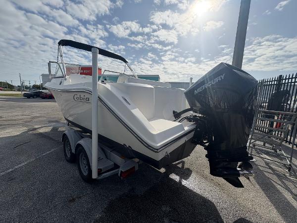 2020 Cobia 220 Dual Console boat on trailer with Mercury outboard motor, parked outdoors.