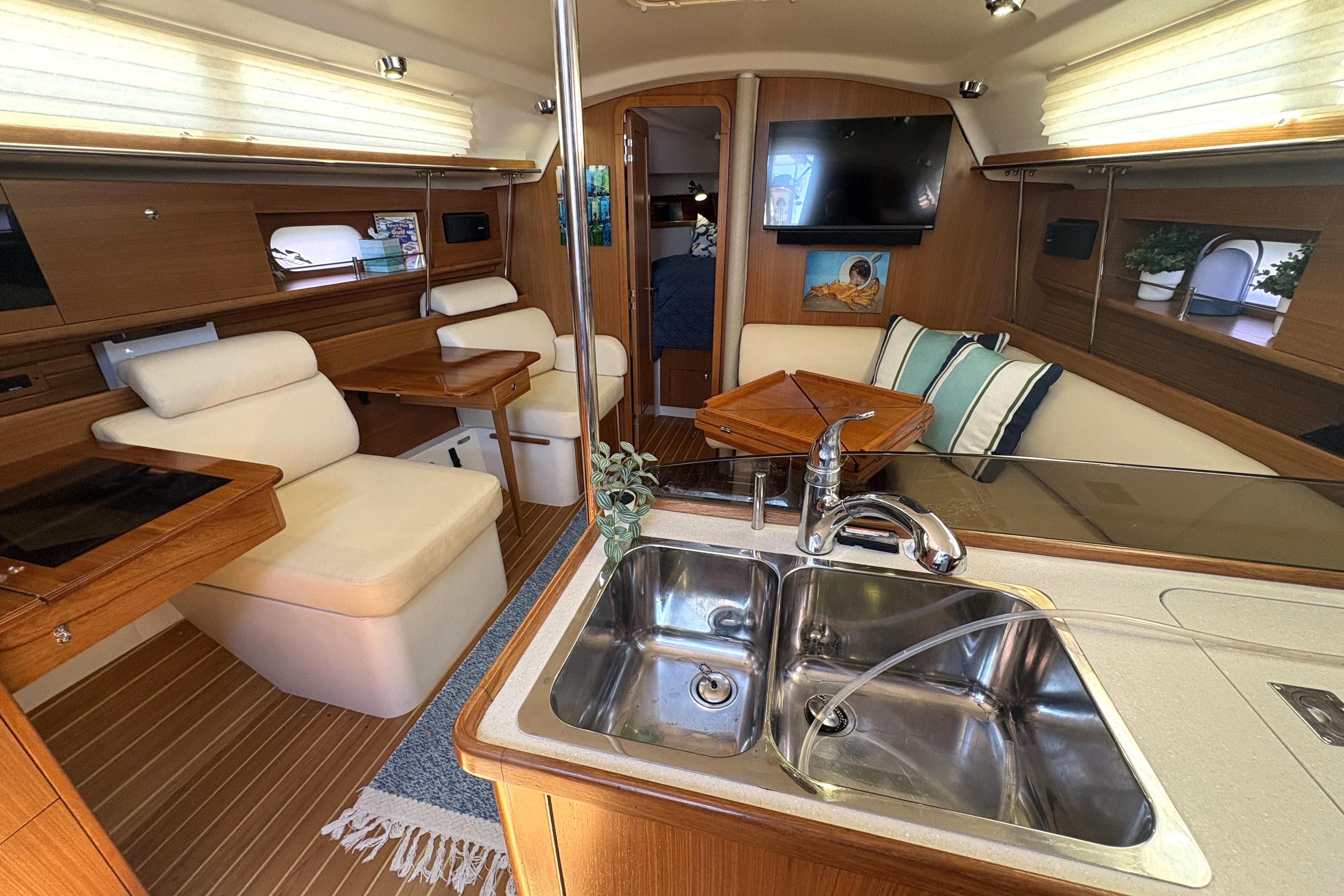 Interior of a 2011 Catalina 355 yacht with modern kitchen and cozy seating area.