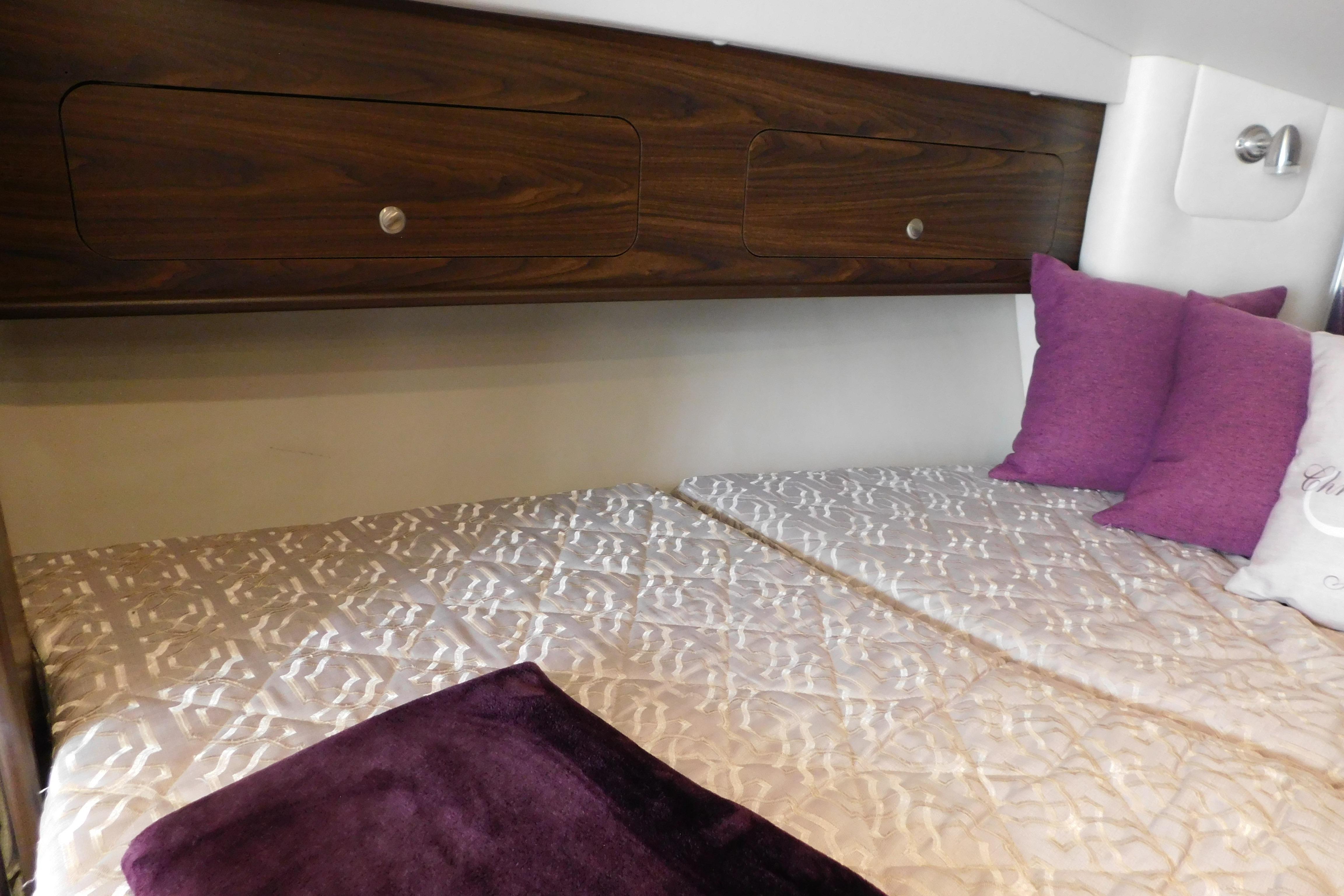 Luxurious cabin interior of 2017 Rinker EX 320 with elegant bedding and purple accents.