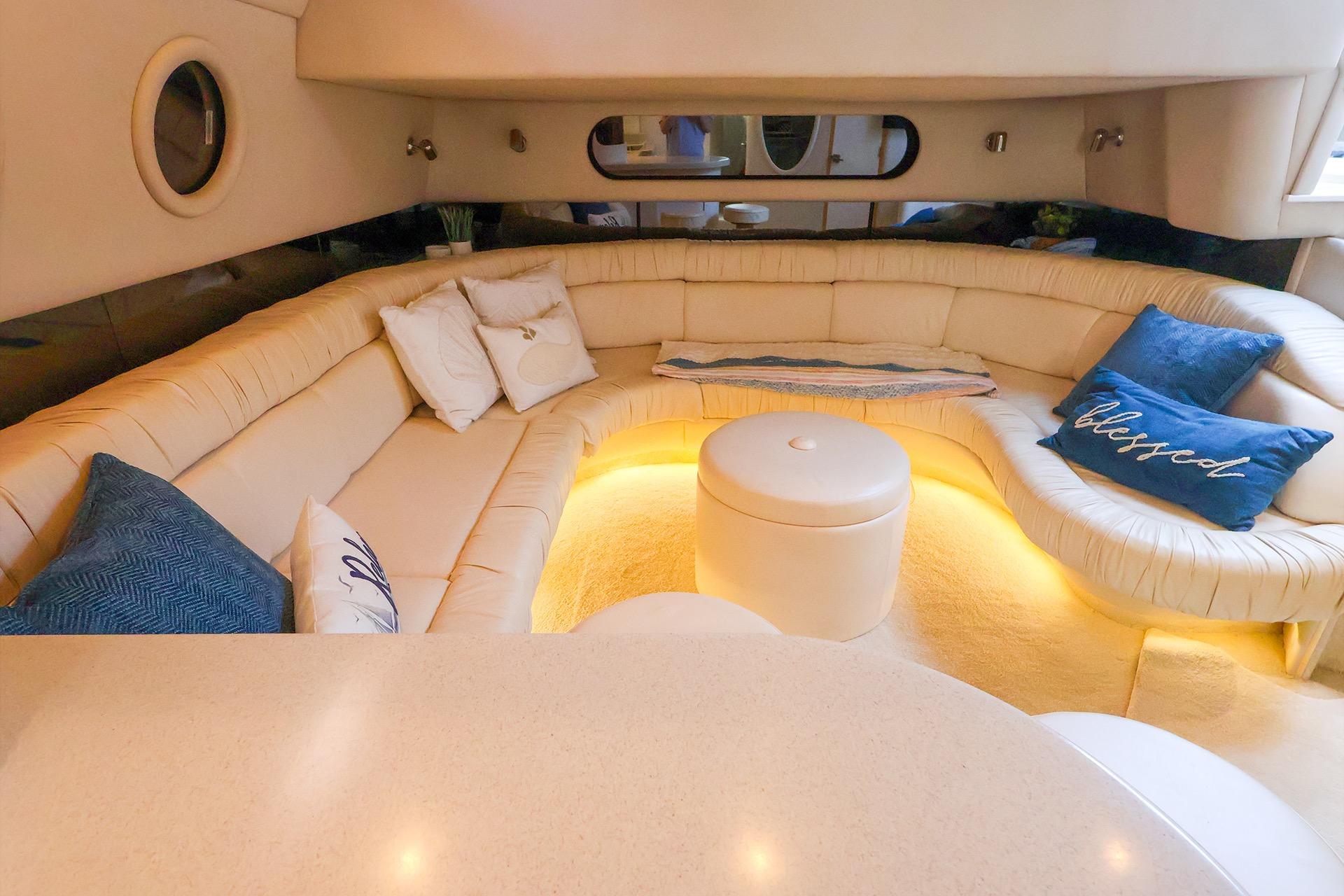 Luxurious interior of a 1998 Sea Ray 500 Sundancer yacht with plush seating and ambient lighting.