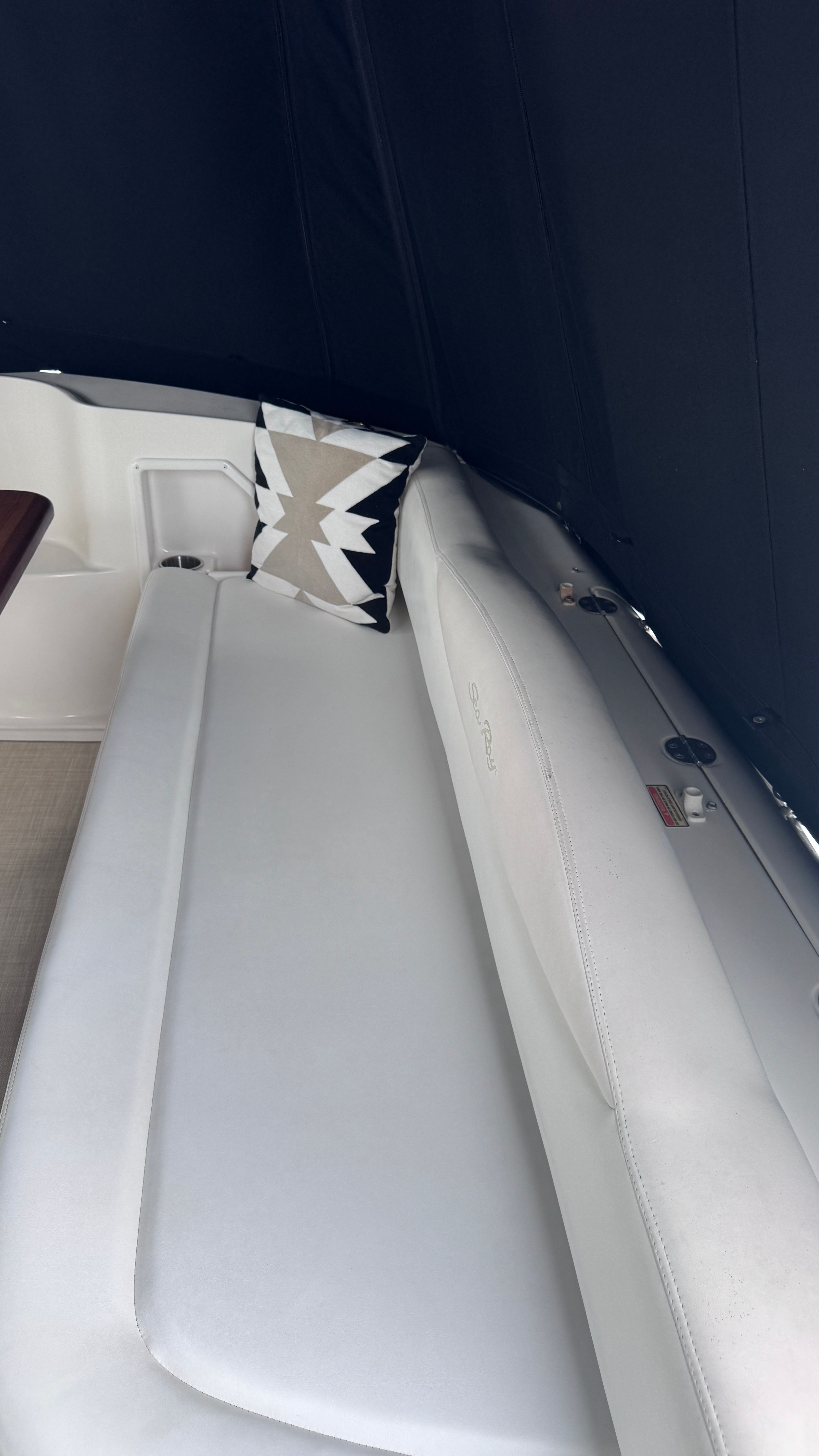 Interior view of the 2003 Sea Ray 360 Sundancer with white upholstery and a cushion.