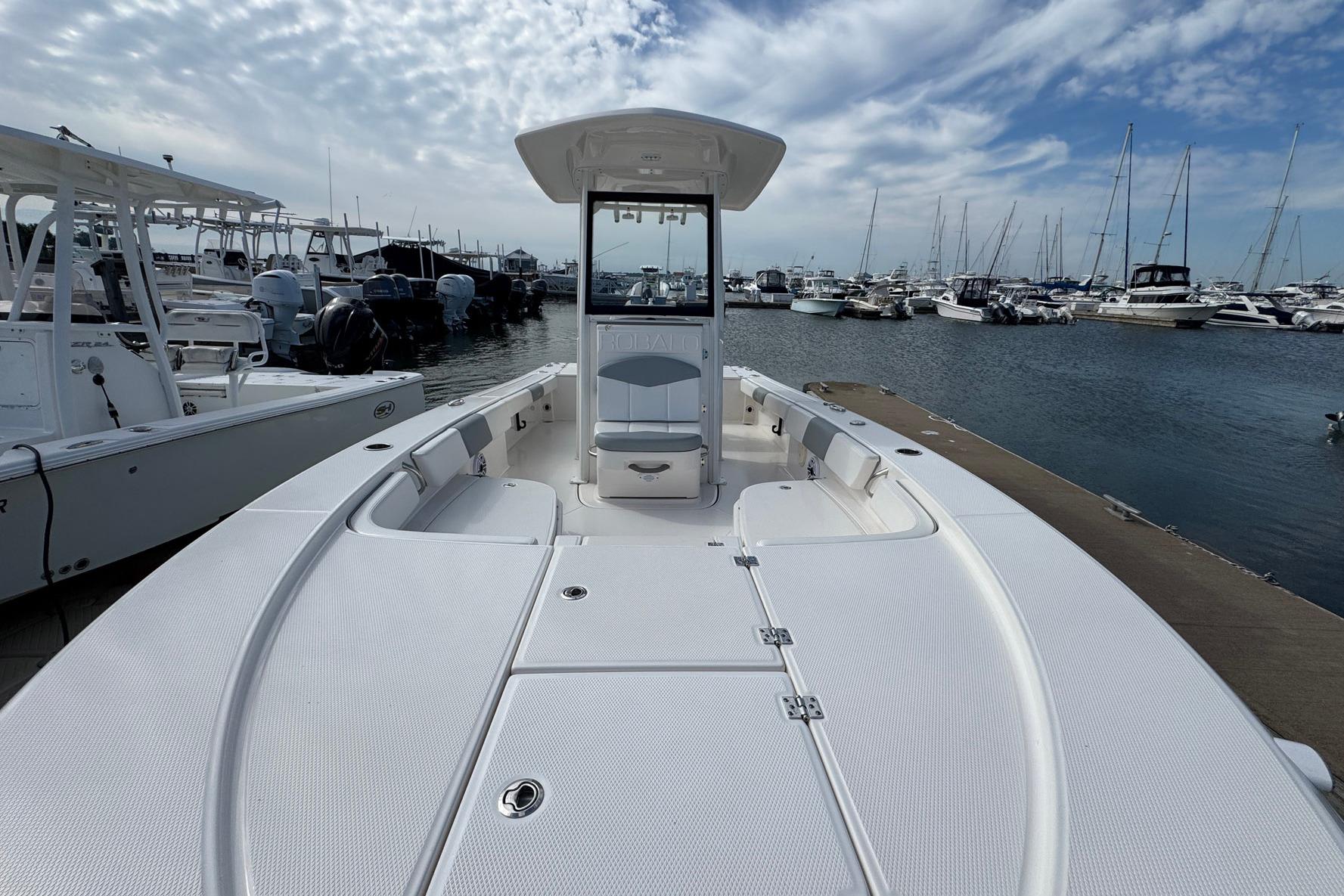 2021 Robalo 246 Cayman boat docked at marina under cloudy sky.