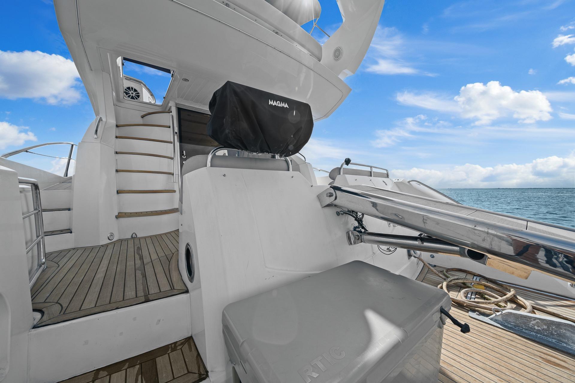2006 Sunseeker Manhattan 50 yacht deck with stairs, ocean view, and clear sky.