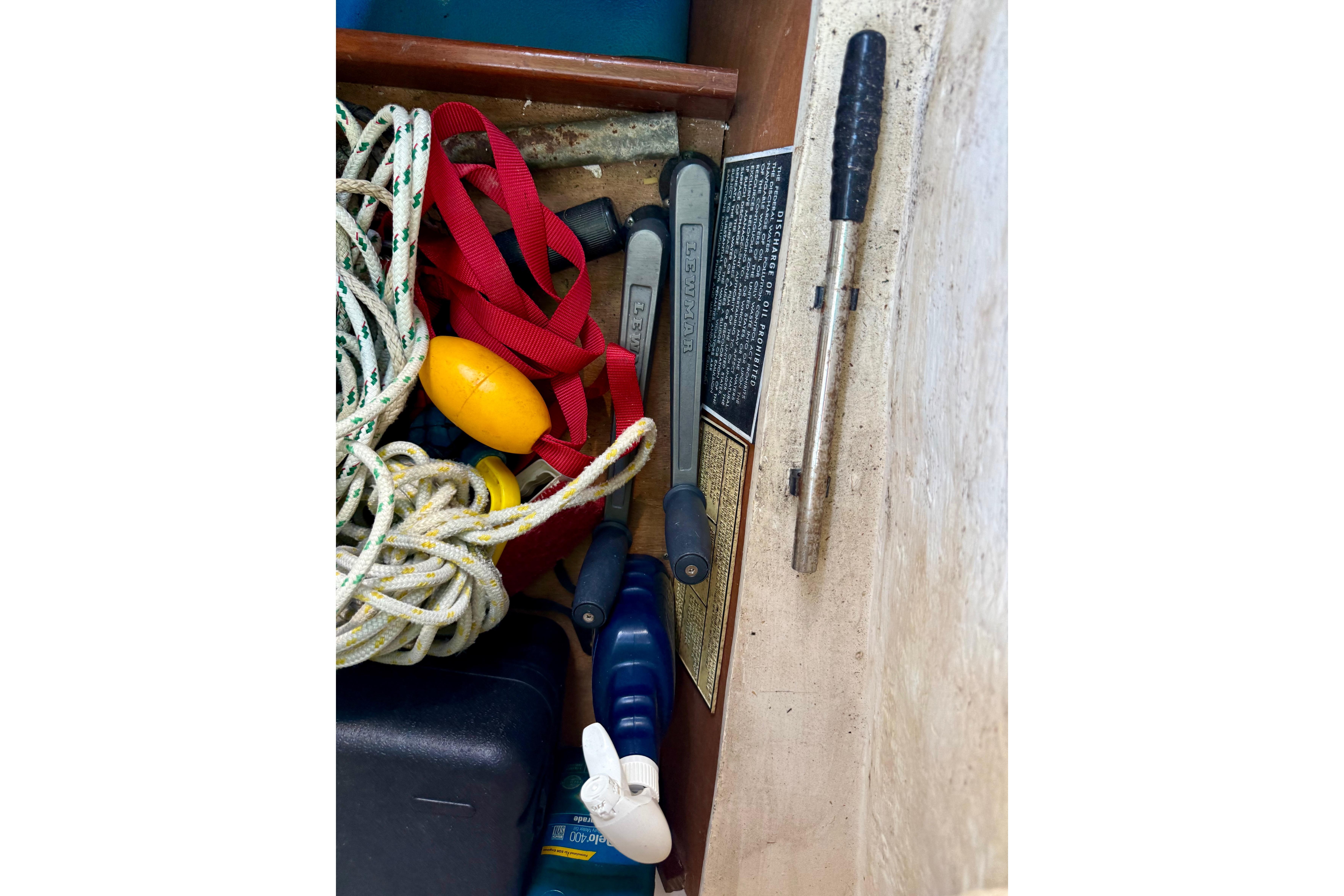 Storage compartment on a 2002 Beneteau Oceanis Clipper 311 with ropes and tools.