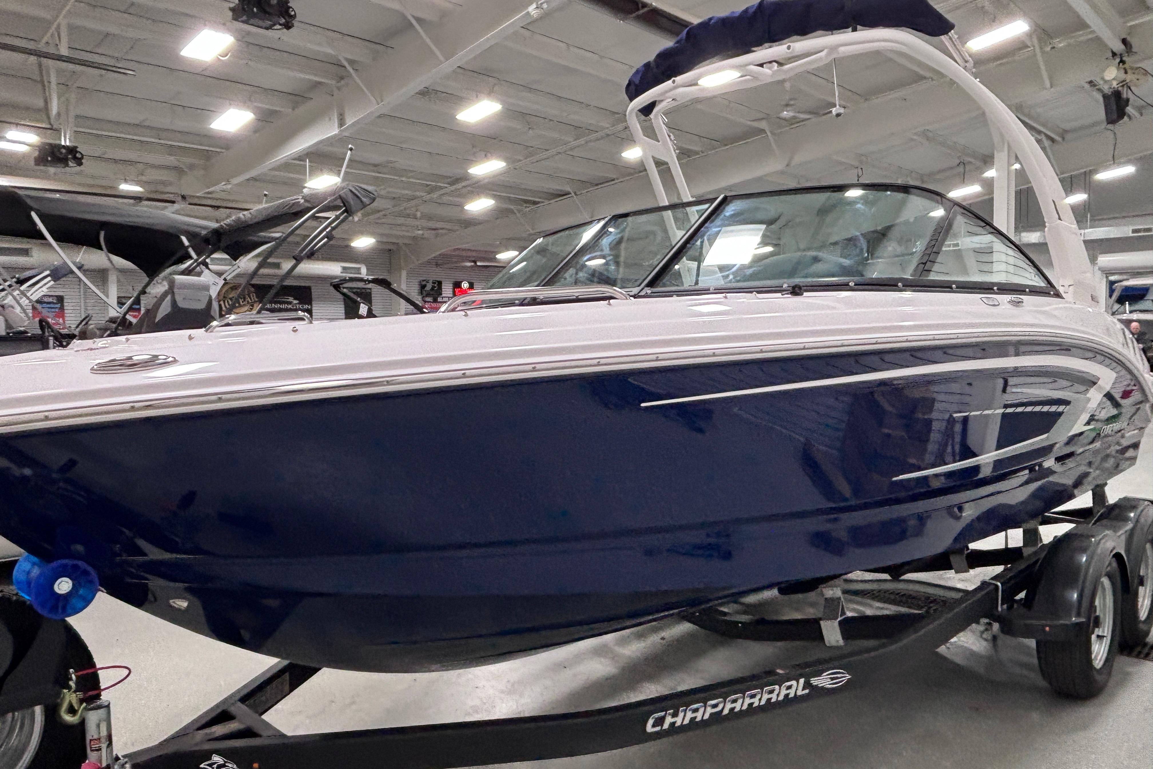 2026 Chaparral 21 SSi boat in showroom, sleek design, blue and white exterior.