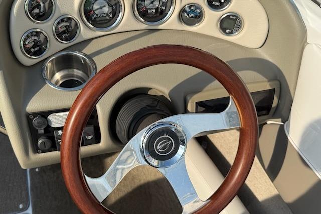 Steering wheel and dashboard of 2012 195 SS boat with gauges and controls.