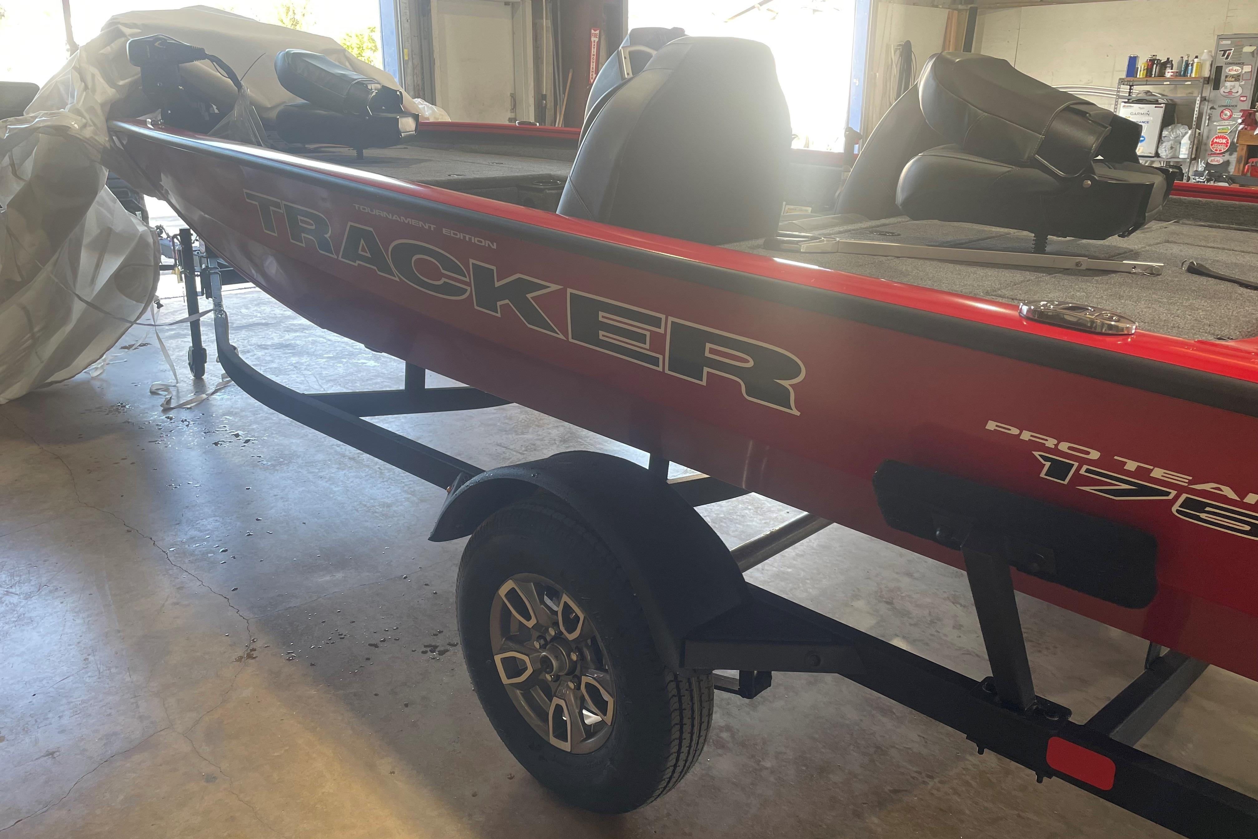2026 Tracker Pro Team 175 boat in a garage, red exterior, on a trailer.