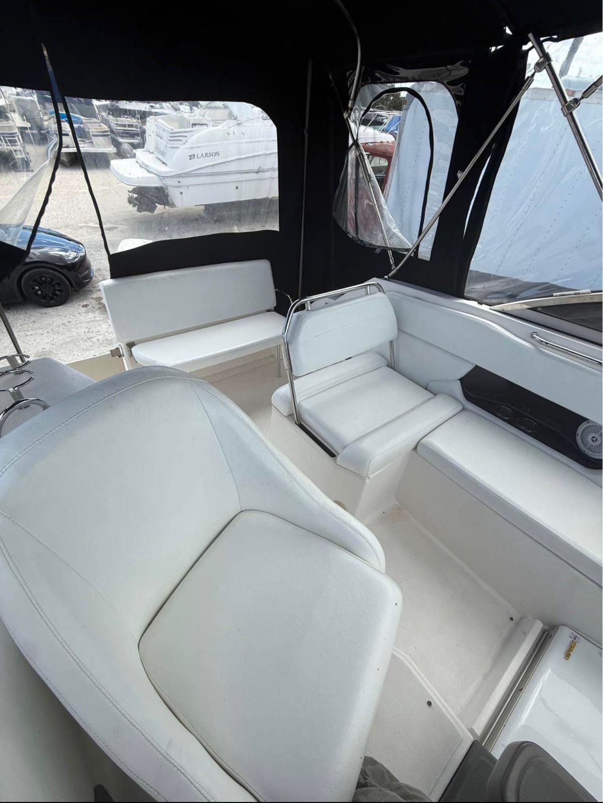 The image shows the cockpit of a 2008 Regal 2565 Window Express boat with white seating.