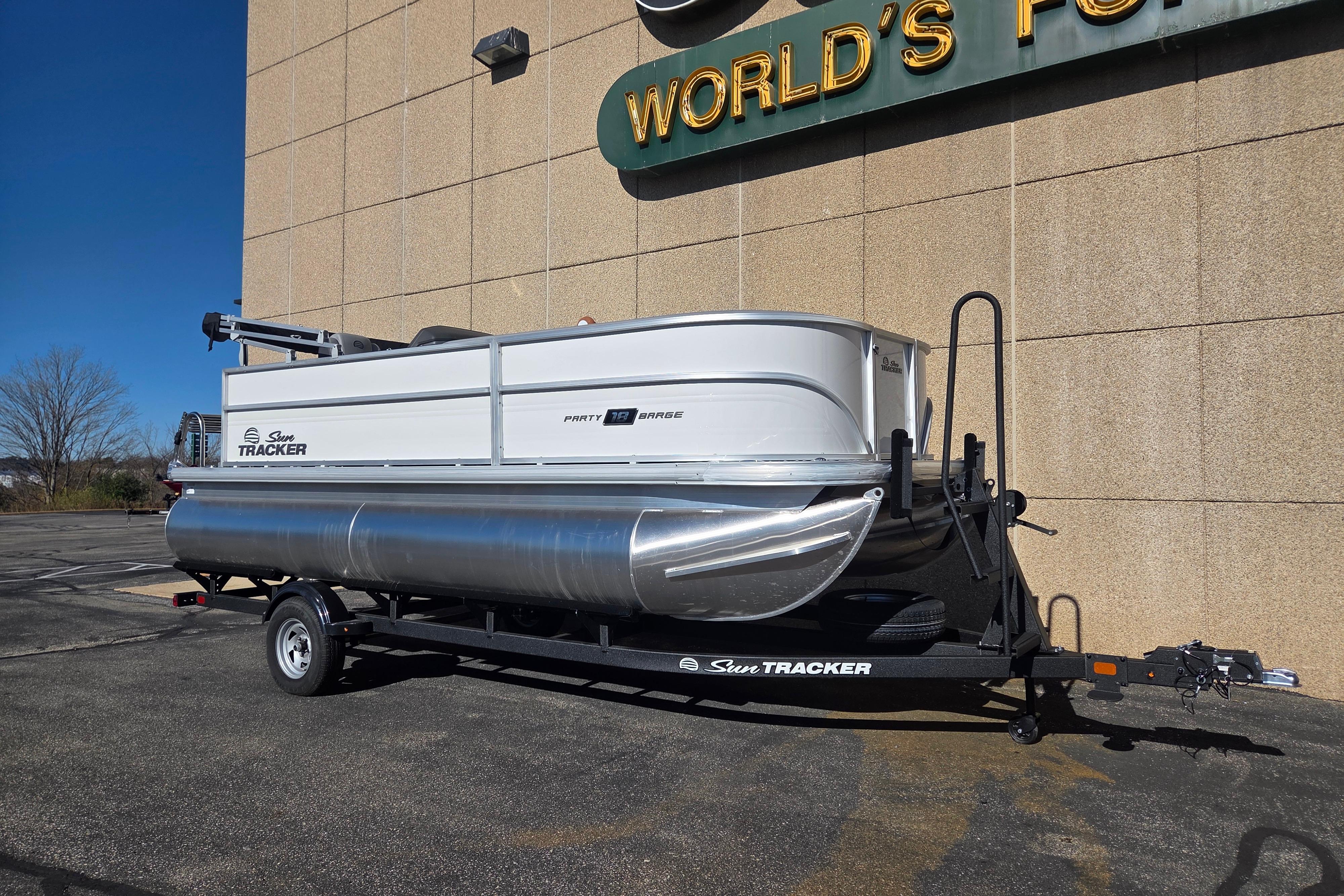 2026 Sun Tracker Party Barge 18 DLX pontoon boat on trailer, parked outdoors.