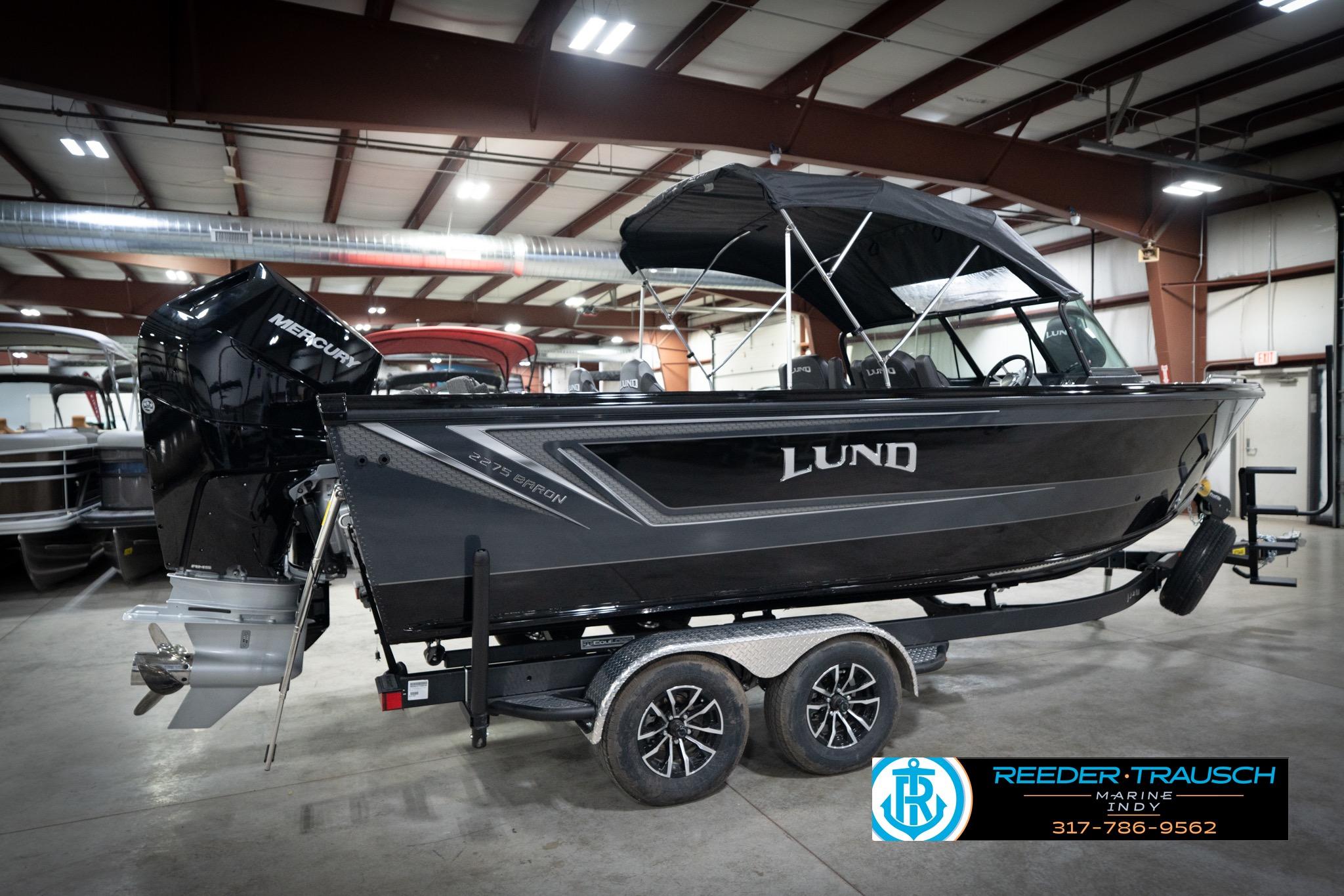 2026 Lund 2275 Baron boat in showroom, featuring Mercury engine and sleek black design.