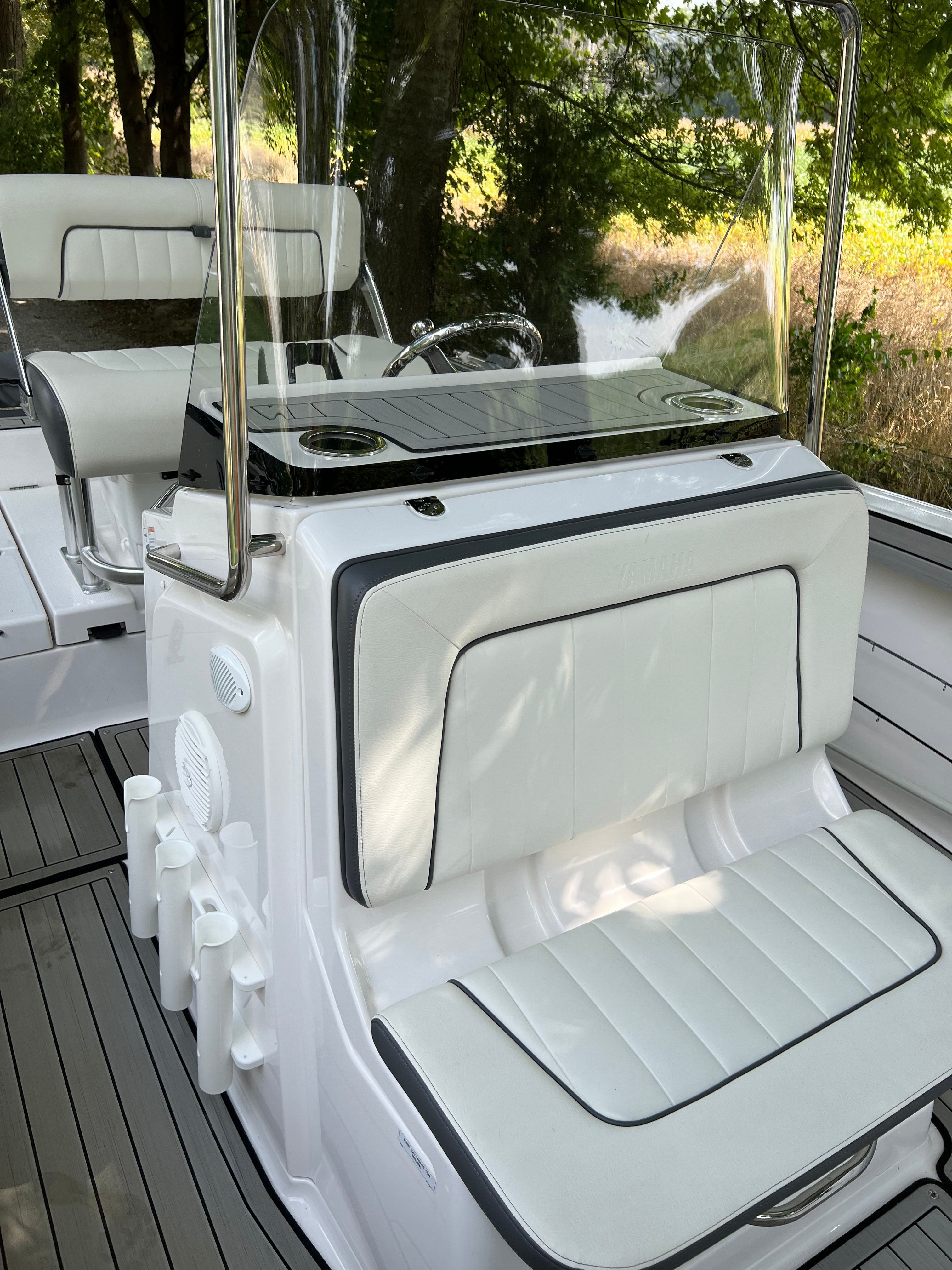 Interior view of 2022 Yamaha Boats 210 FSH Deluxe with white seating area.