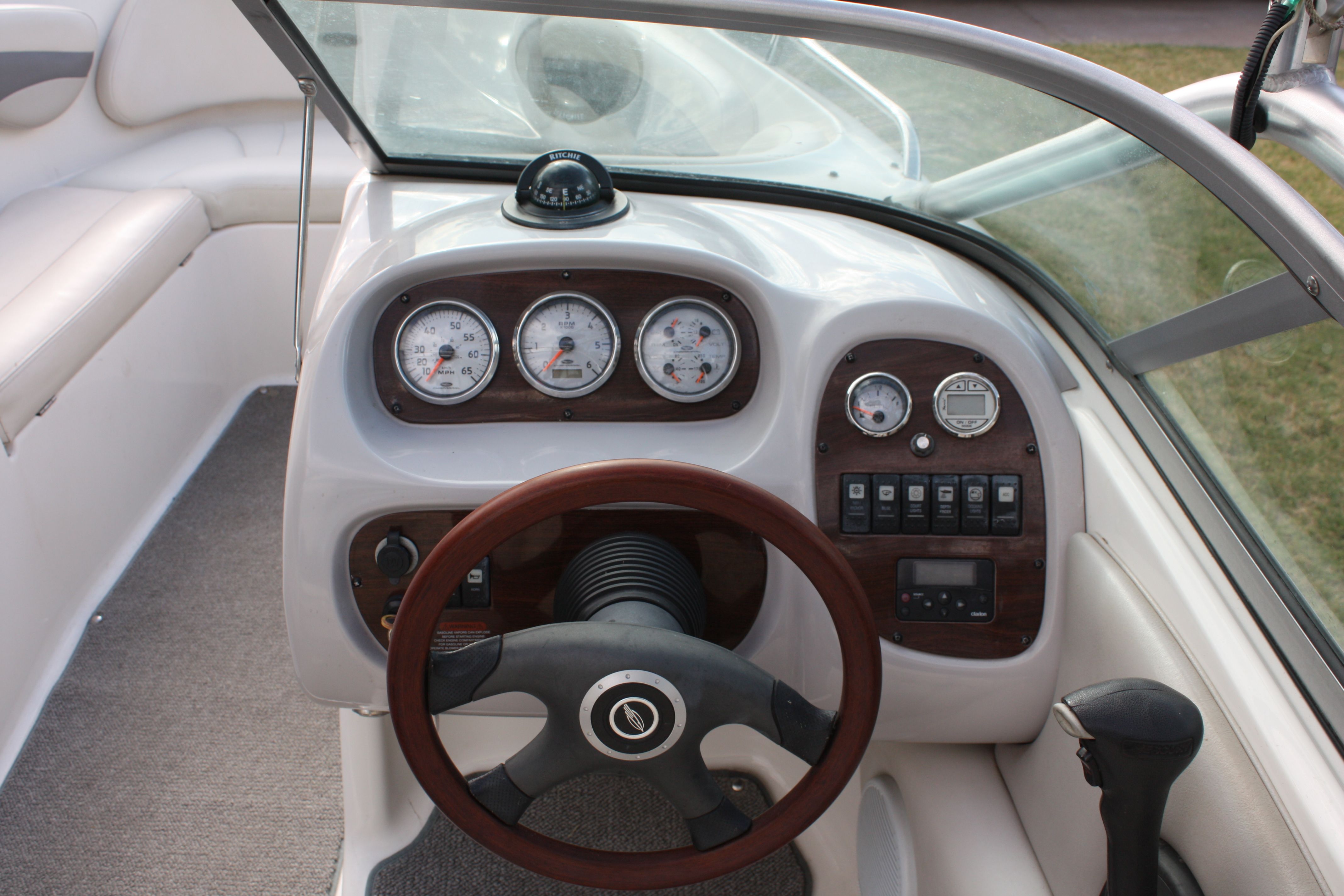 The image shows the cockpit of a 2007 Chaparral 210 SSi boat with a wood steering wheel.