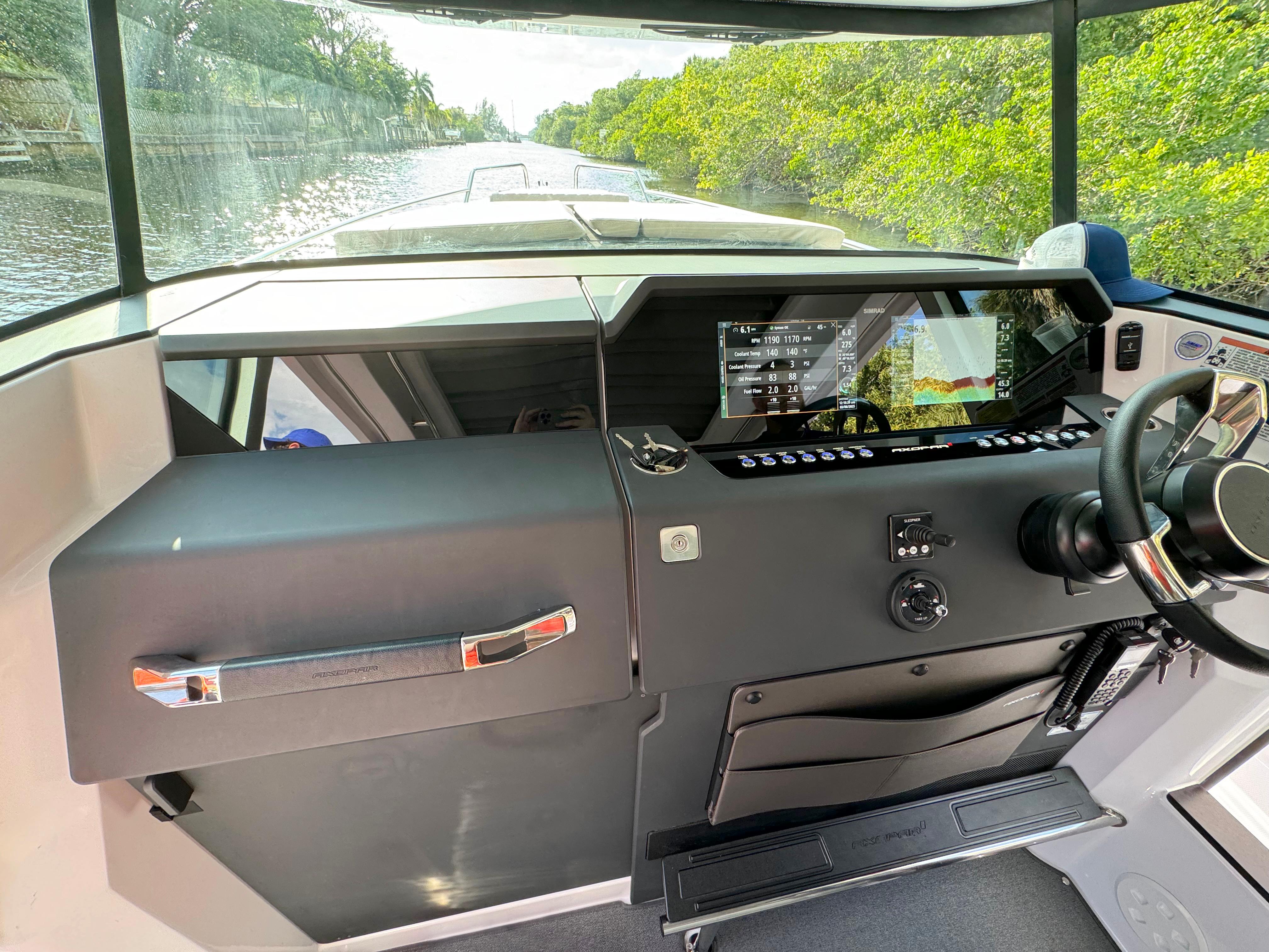 2024 Axopar 37XC CROSS CABIN helm with modern controls and scenic waterway view.