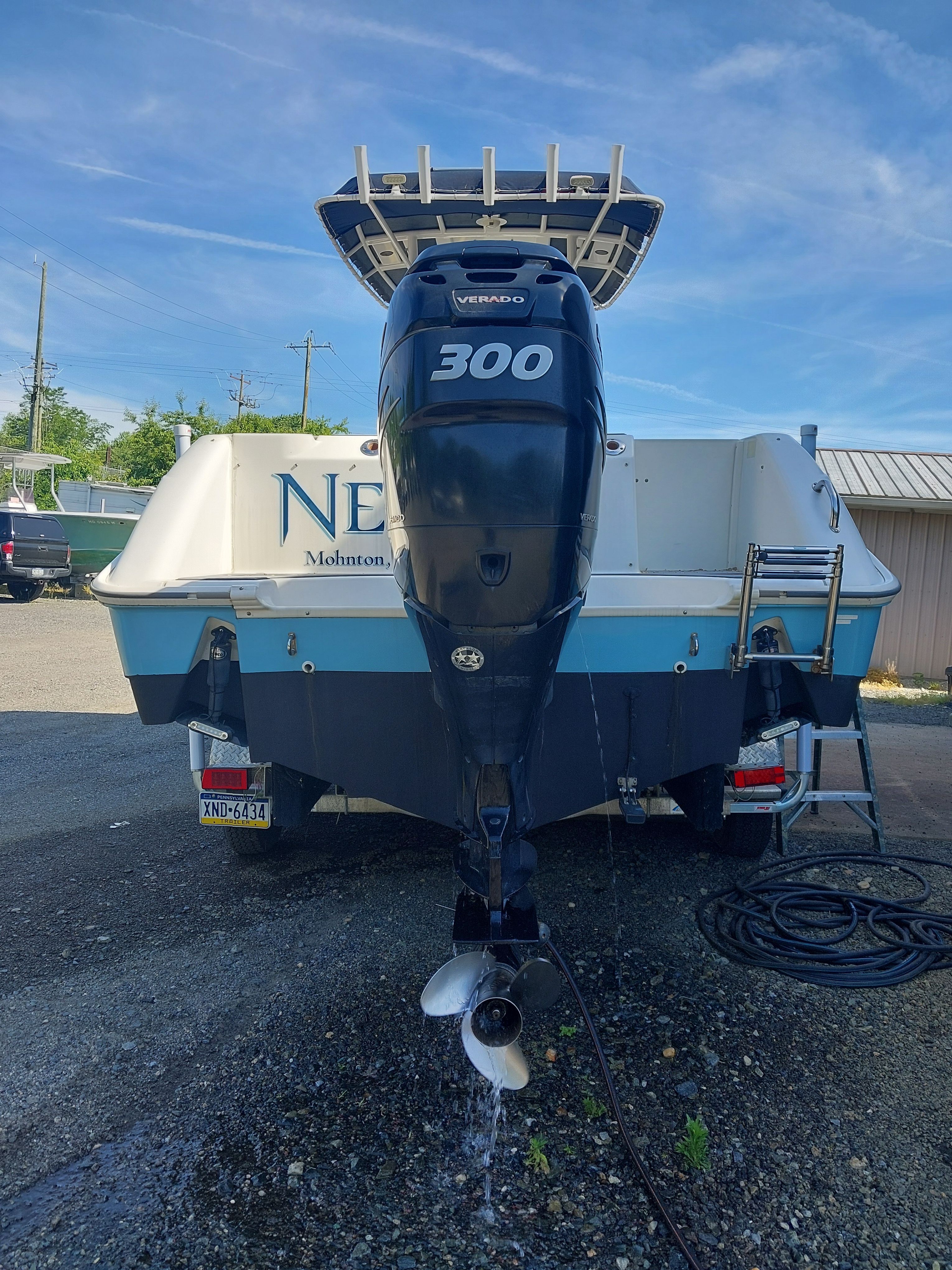 A 2005 Boston Whaler 240 Outrage with a large outboard motor in a parking area.