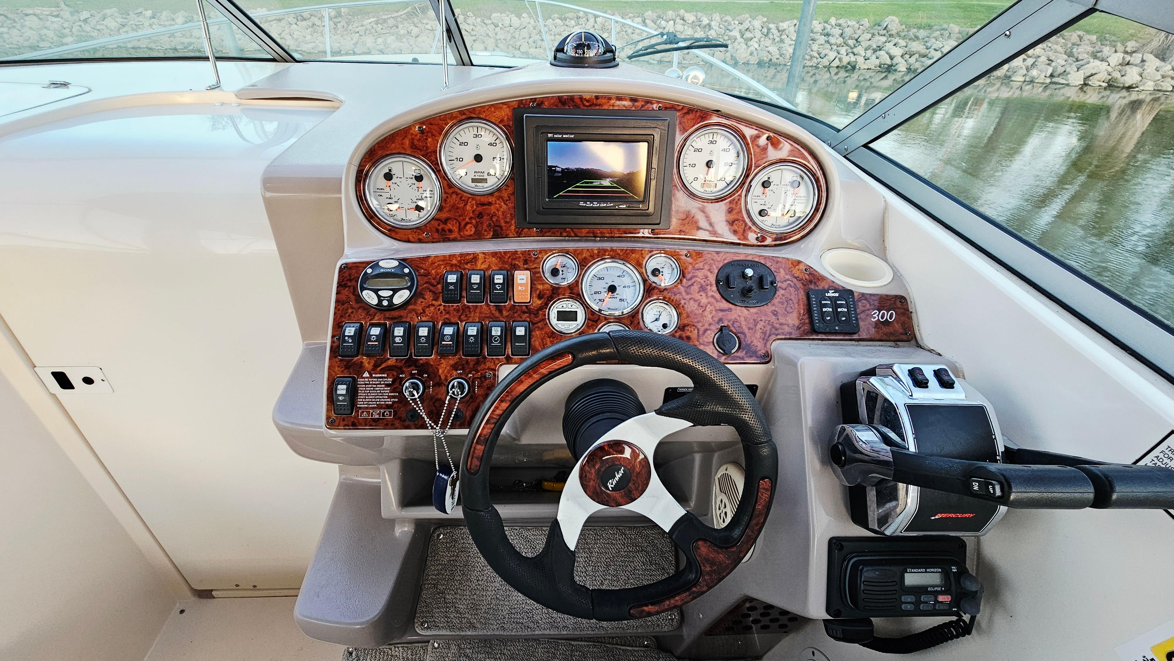 2005 Rinker 300 Express Cruiser dashboard with steering wheel and control panel.