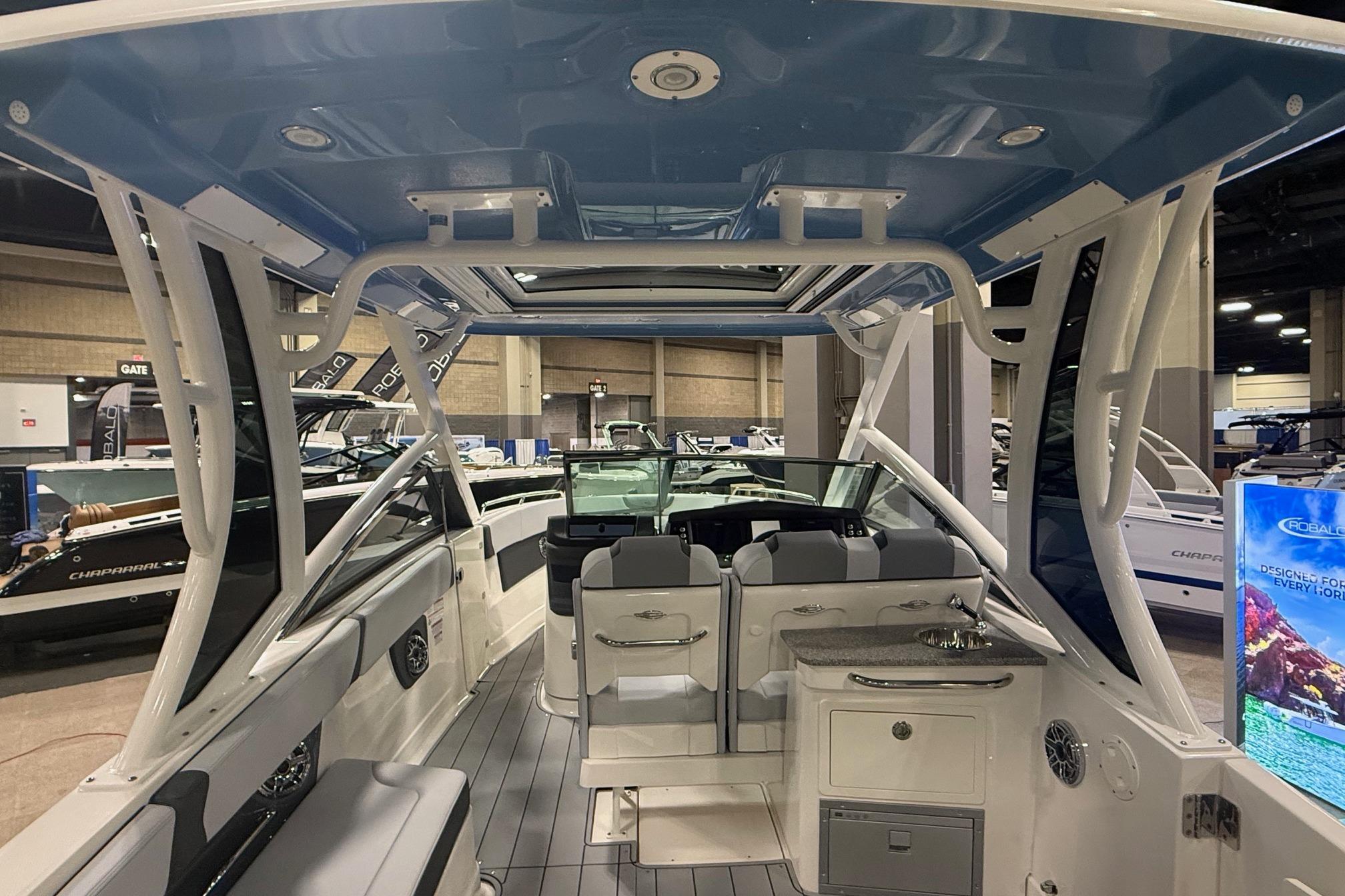 2026 Chaparral 280 OSX boat interior with seating and helm, showcased indoors.