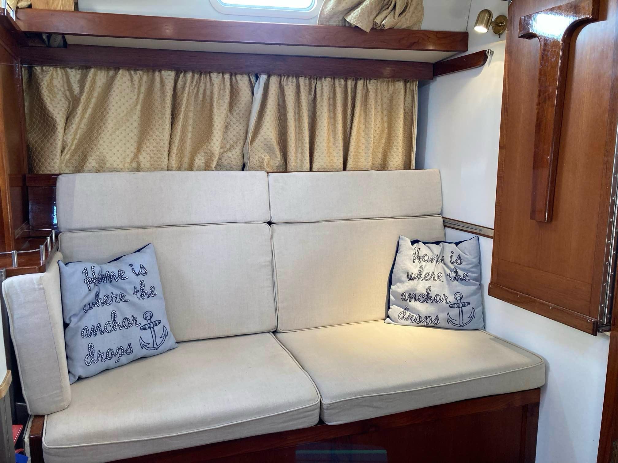 Cozy interior of 2014 Bruce Roberts Spray A370 yacht with beige cushions and nautical pillows.