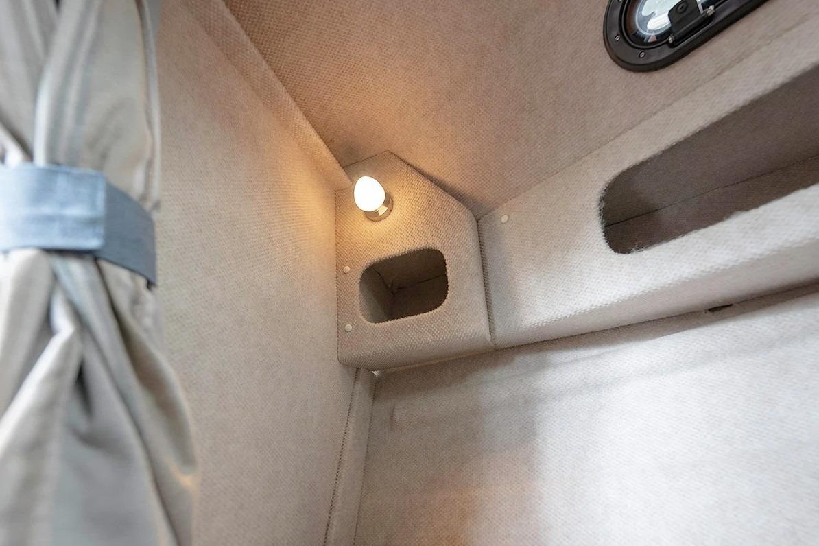 Interior cabin of 2026 KingFisher 3225 GFX Offshore boat, featuring cozy lighting and storage.
