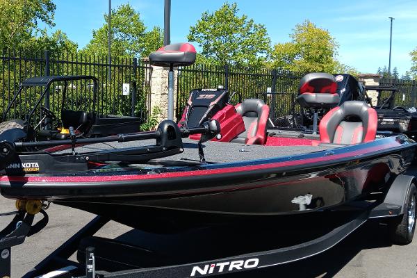 2025 Nitro Z19 boat with red and black design, parked outdoors.