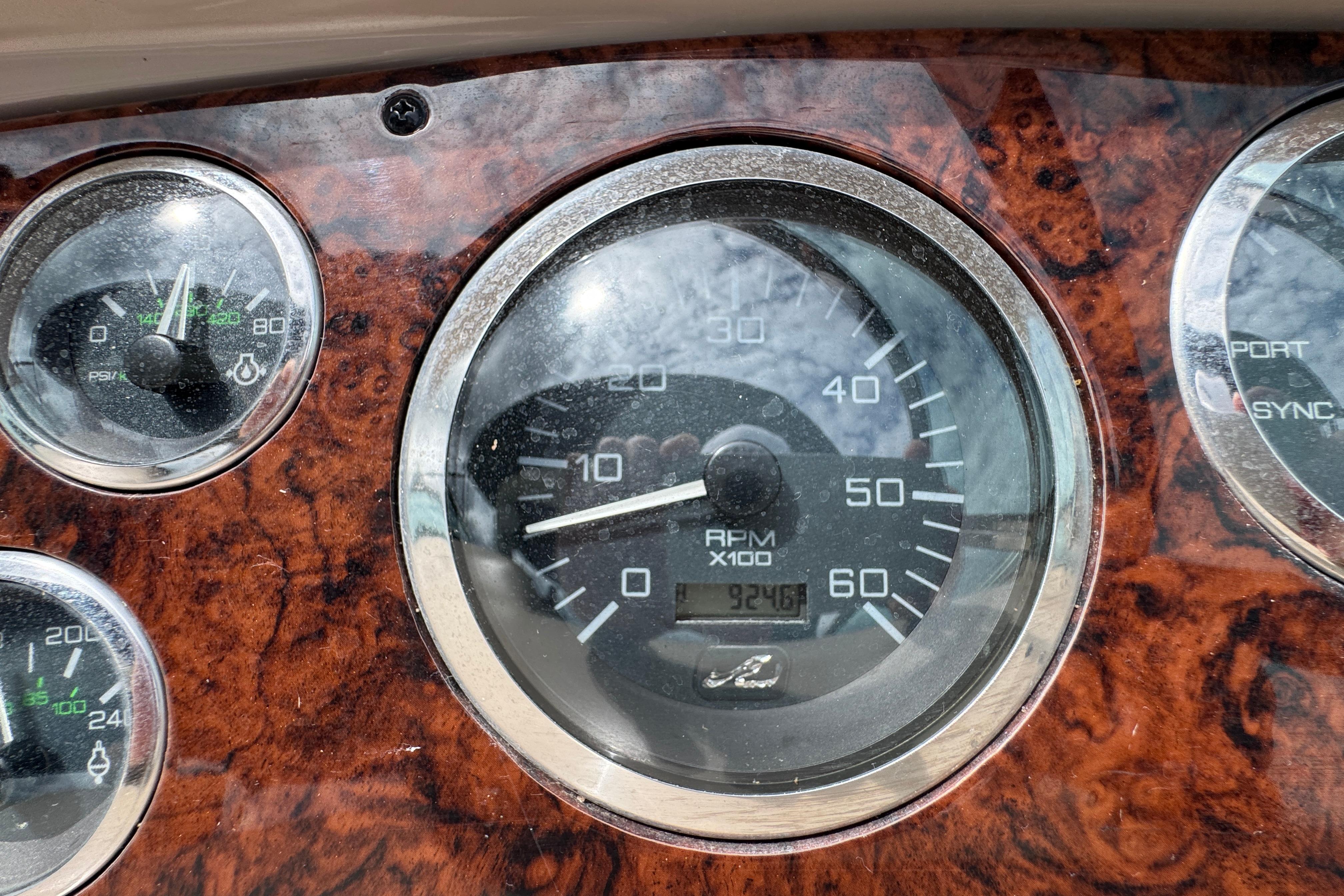 Close-up of 2001 Sea Ray 380 Sundancer dashboard gauges, featuring RPM and pressure indicators.