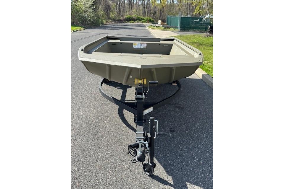 2026 Tracker Grizzly 1860 Utility boat on trailer, parked on asphalt road.