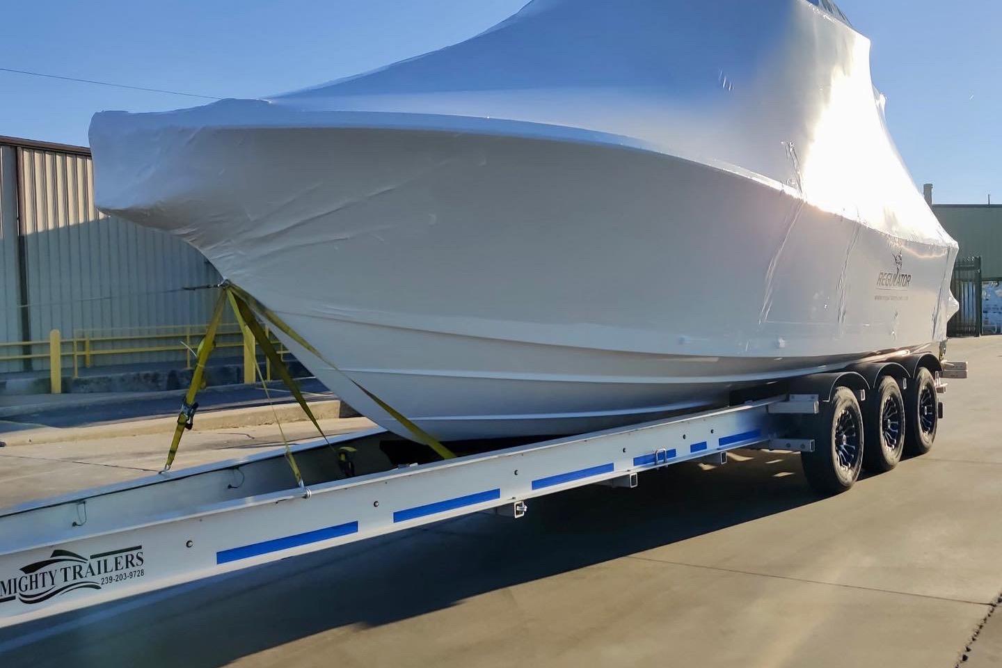 2022 Regulator 28 boat covered on a trailer, parked outdoors.