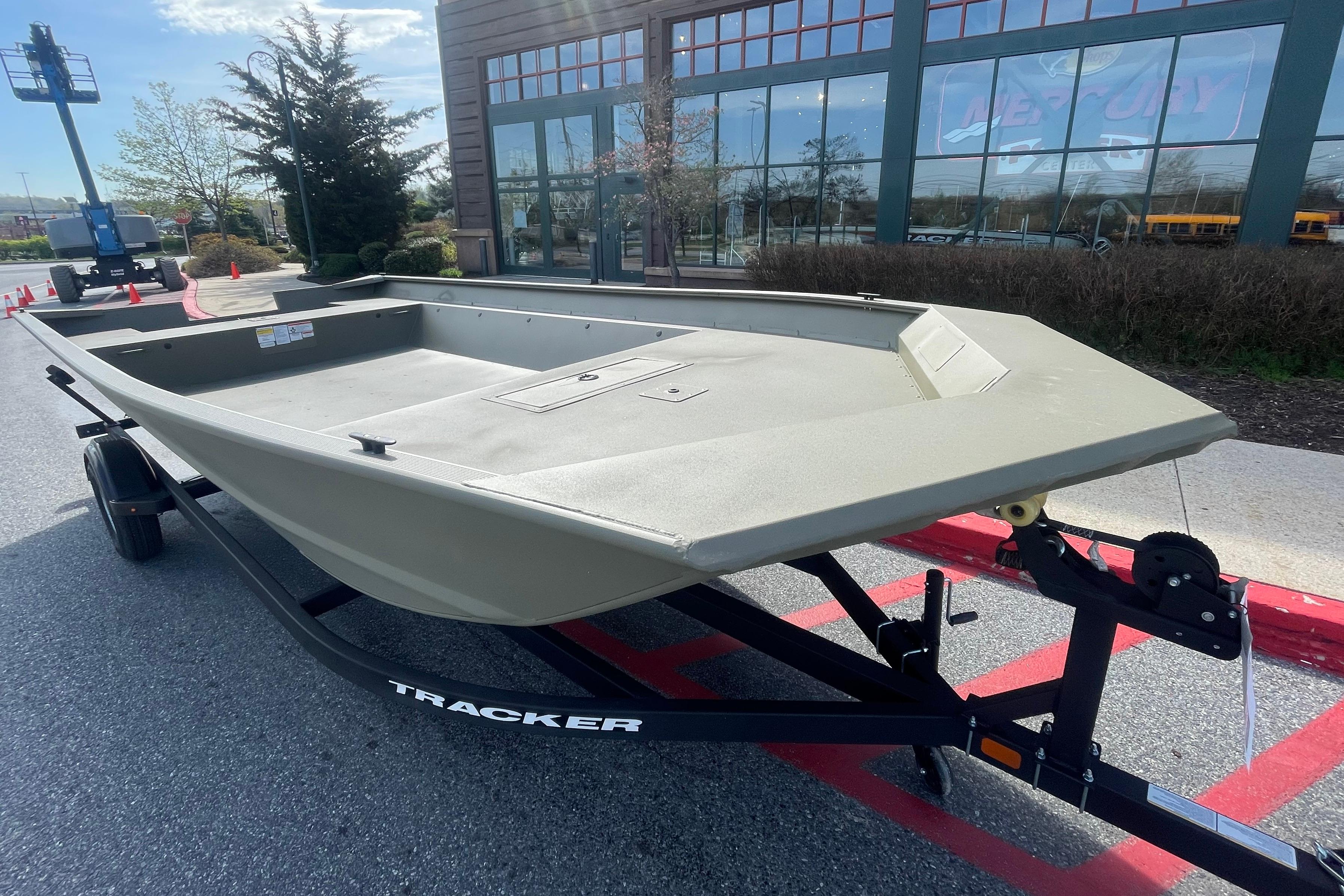 2026 Tracker Grizzly 2072 Utility boat on trailer outside dealership.